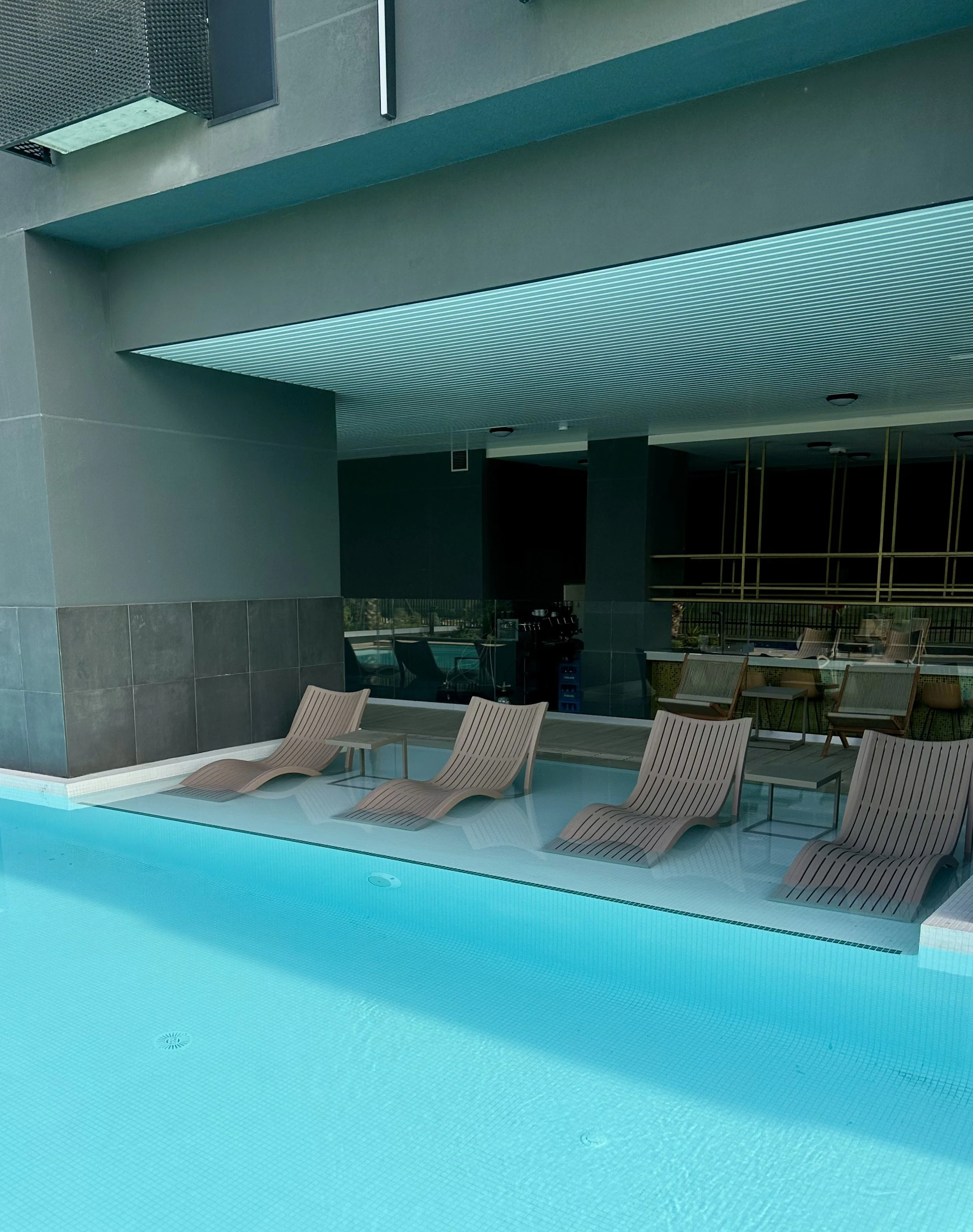 Stylish outdoor swimming pool with submerged loungers for relaxing under the Madrid sun
