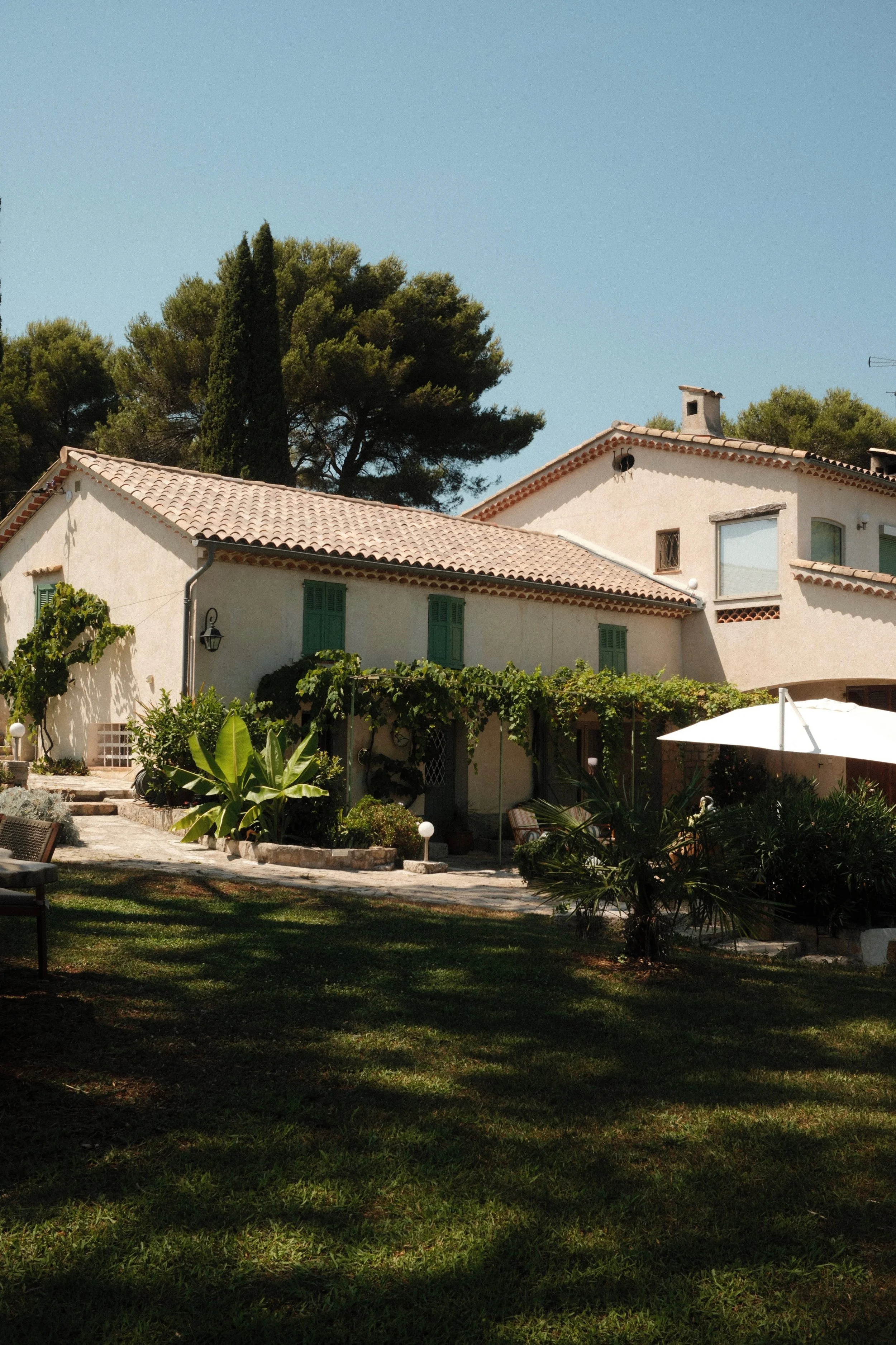 Sunlit guest house surrounded by lush gardens and Provençal architecture