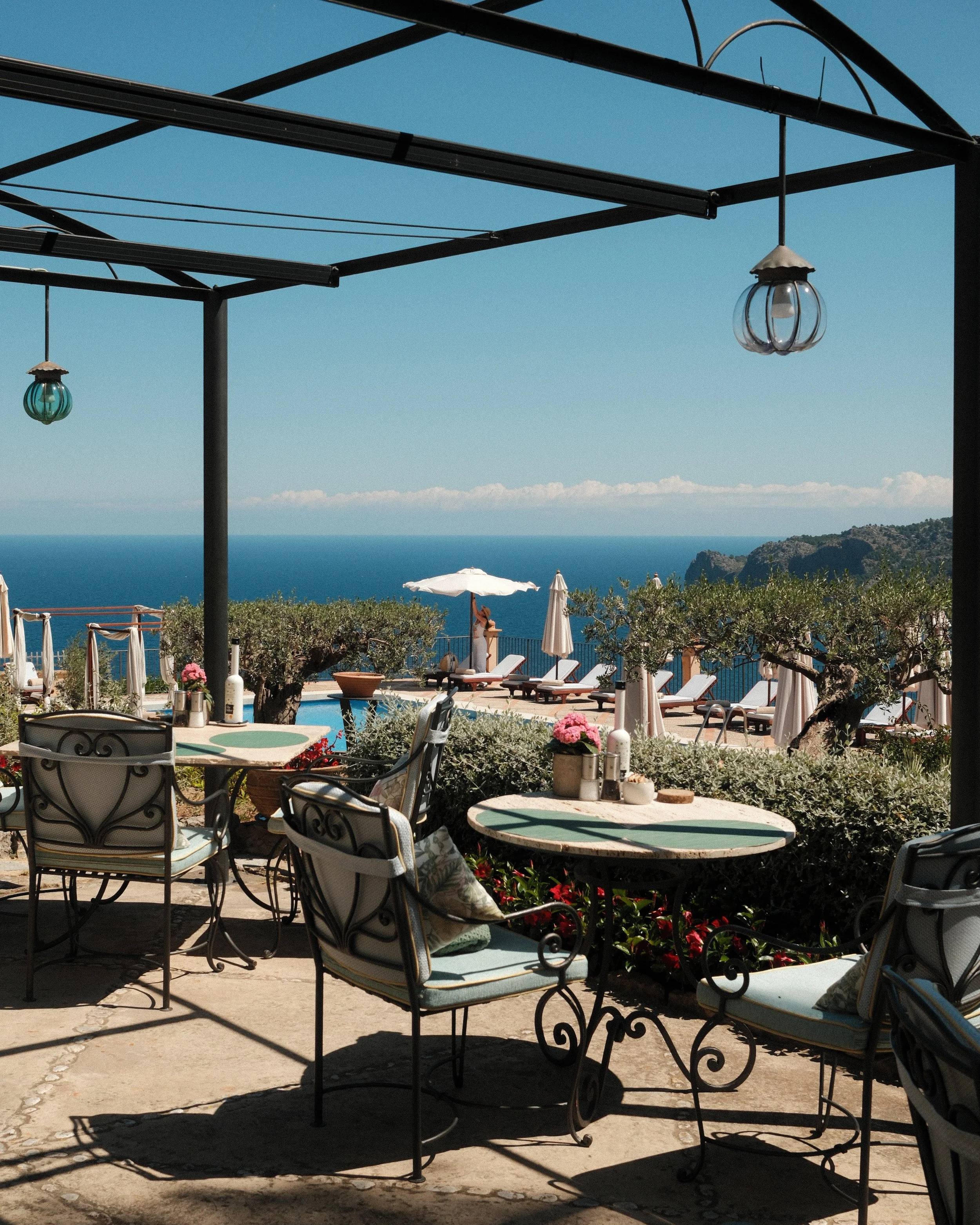 Outdoor terrace with elegant seating overlooking the infinity pool and the Mediterranean Sea