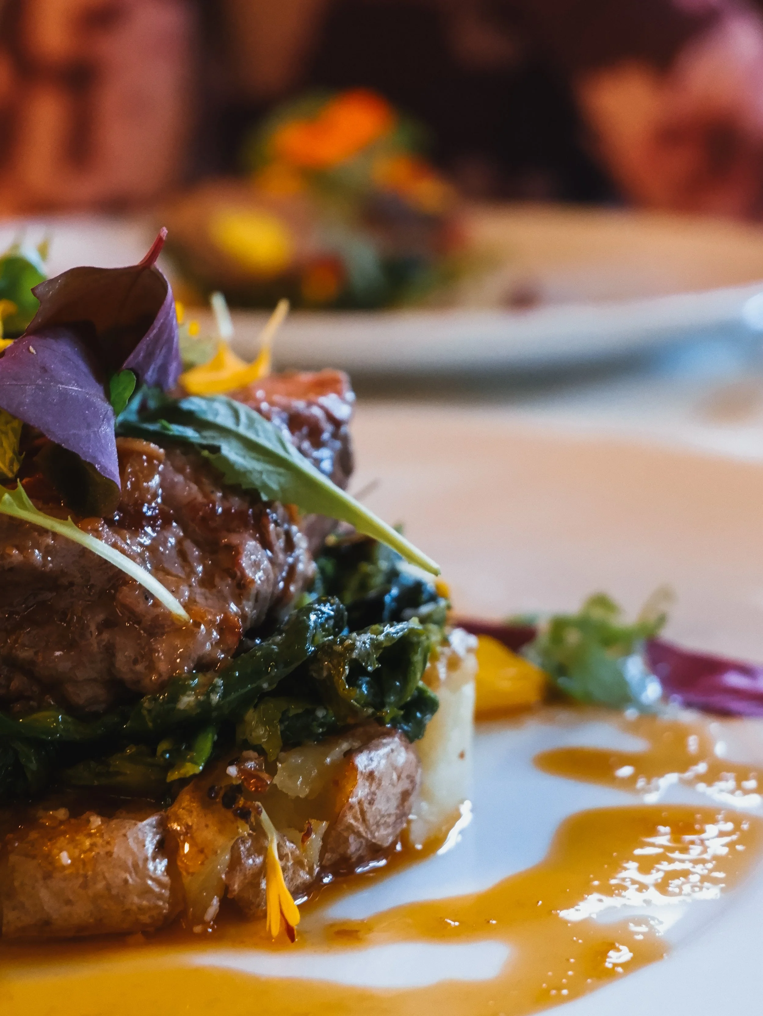 Refined gourmet meat dish served with seasonal vegetables and rich culinary presentation at a fine dining restaurant