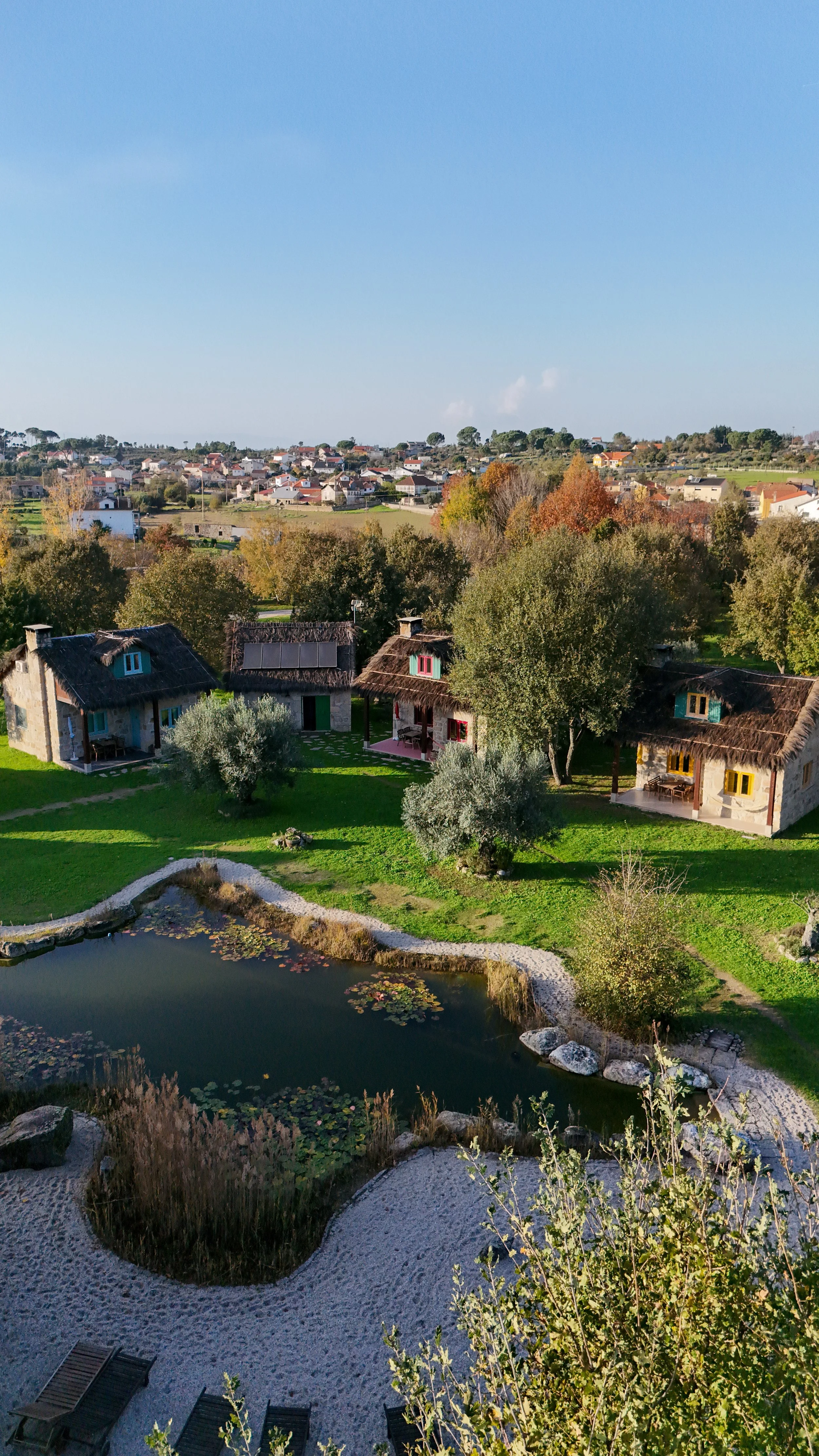 Rustic stone cottages overlooking the natural swimming pond at Chão do Rio in Serra da Estrela