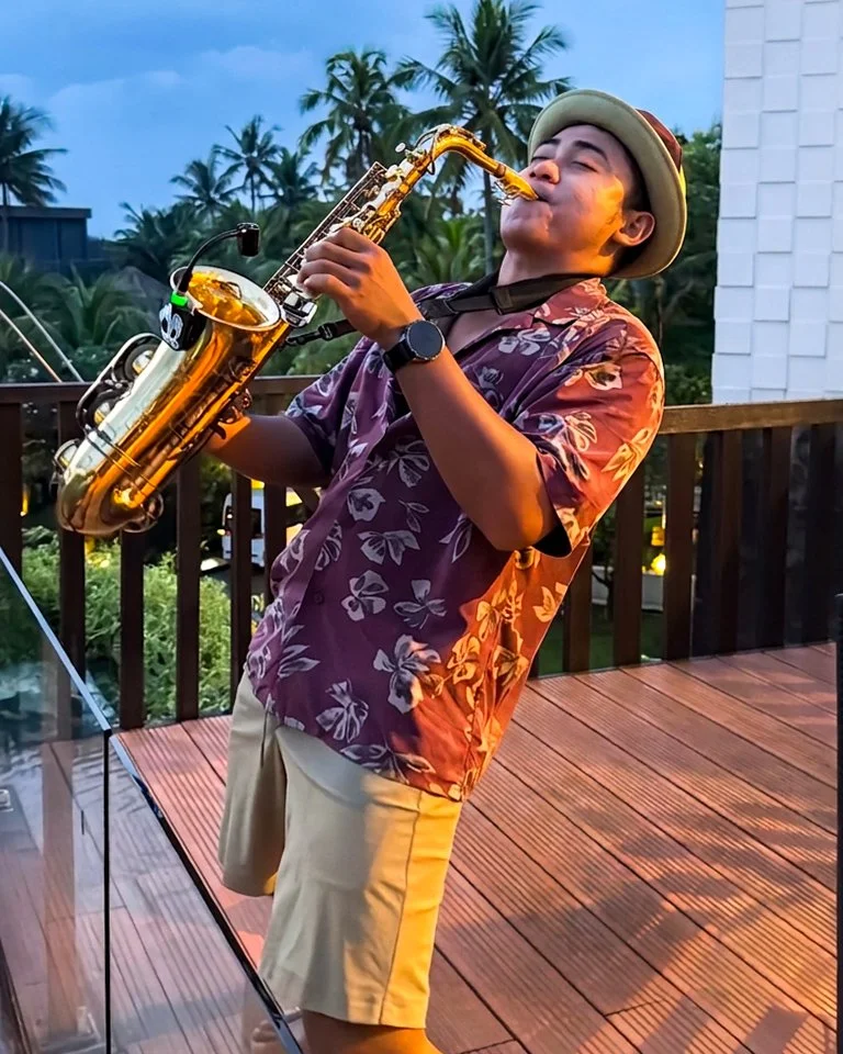 Sunset saxophone performance on terrace overlooking tropical surroundings at Pullman Bali