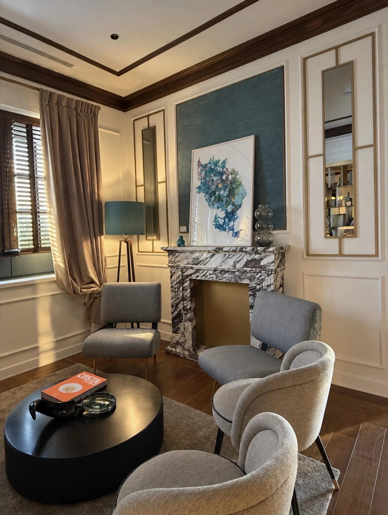 Refined lounge with marble fireplace, contemporary artwork, soft seating, and turquoise accents