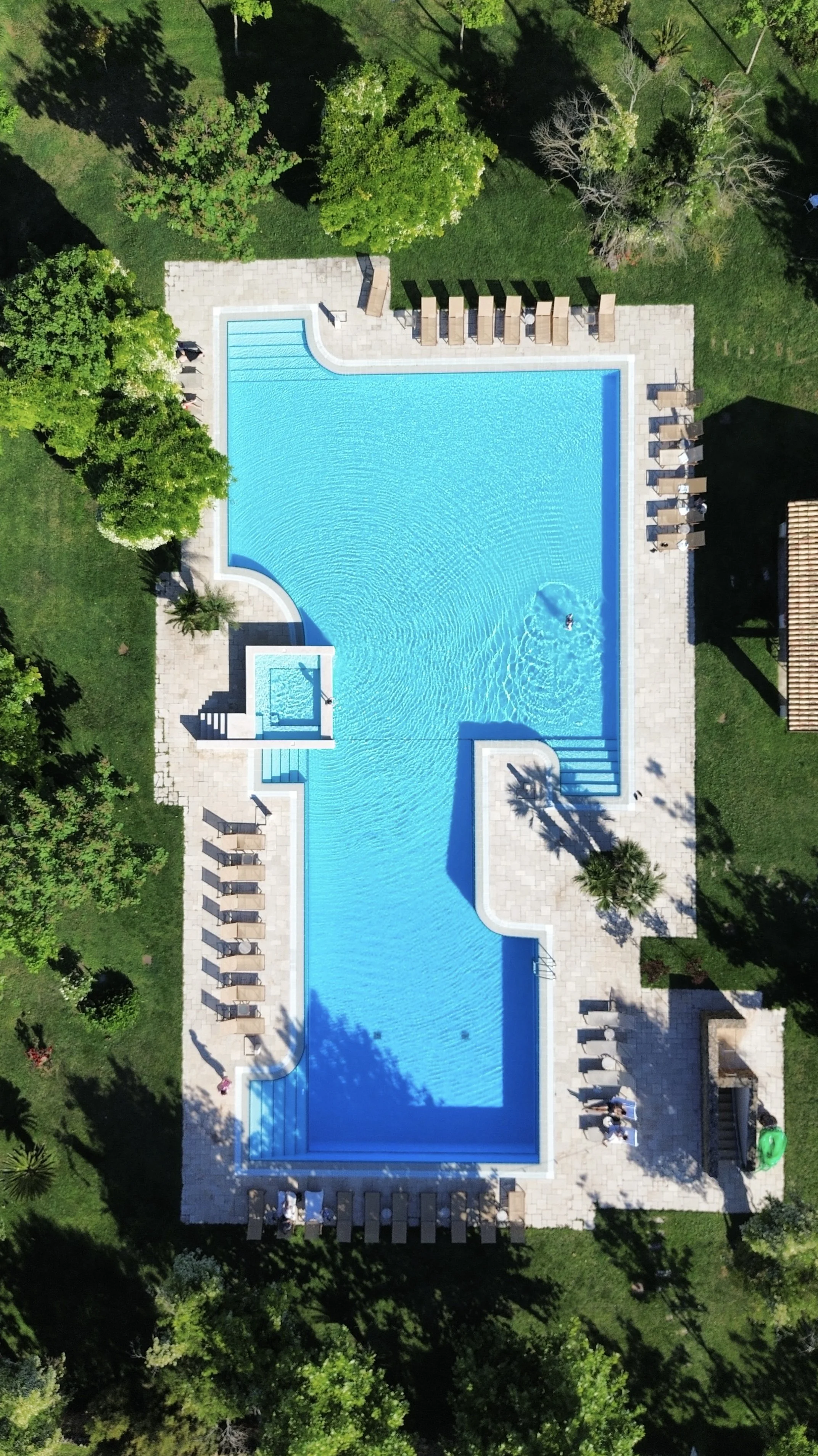 Aerial view of the resort’s expansive swimming pool set within lush Mediterranean gardens at Tenuta Monacelli Lecce