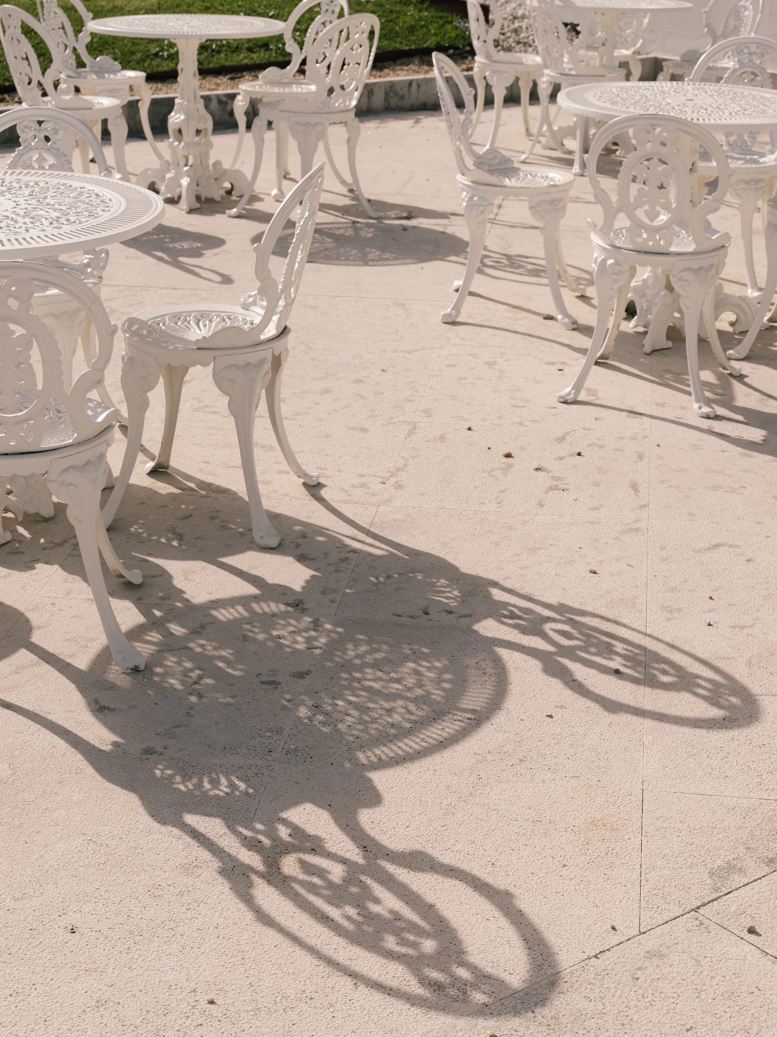 Sunlit terrace detail with intricate chair shadows and classic design at Eurostars Hotel Real