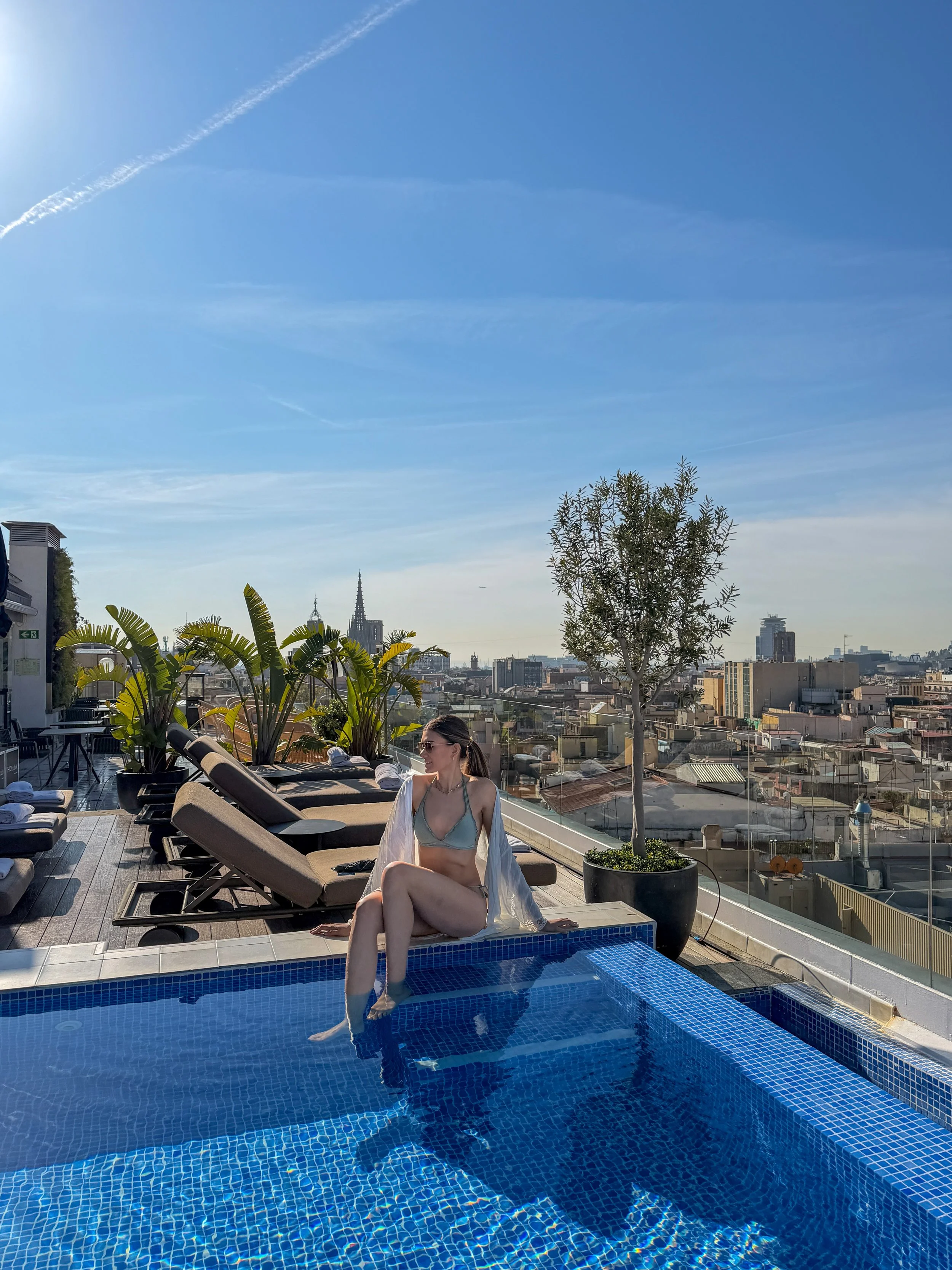 Rooftop plunge pool with sun loungers and skyline views under clear blue skies in Barcelona, H10 Cubik Barcelona – Barcelona, Spain.