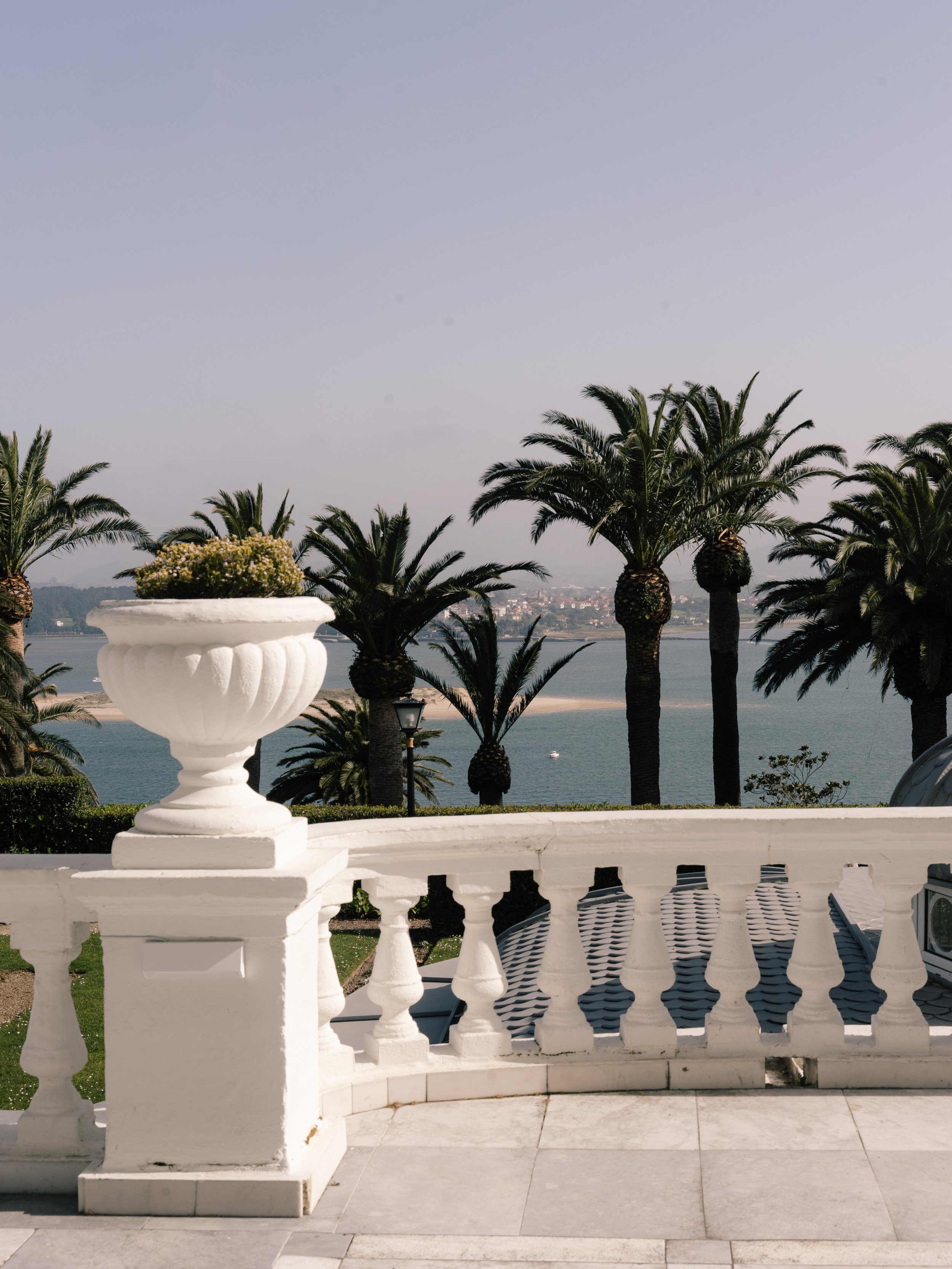 Ocean view framed by palm trees and white balustrade terrace at Eurostars Hotel Real in Santander, Spain