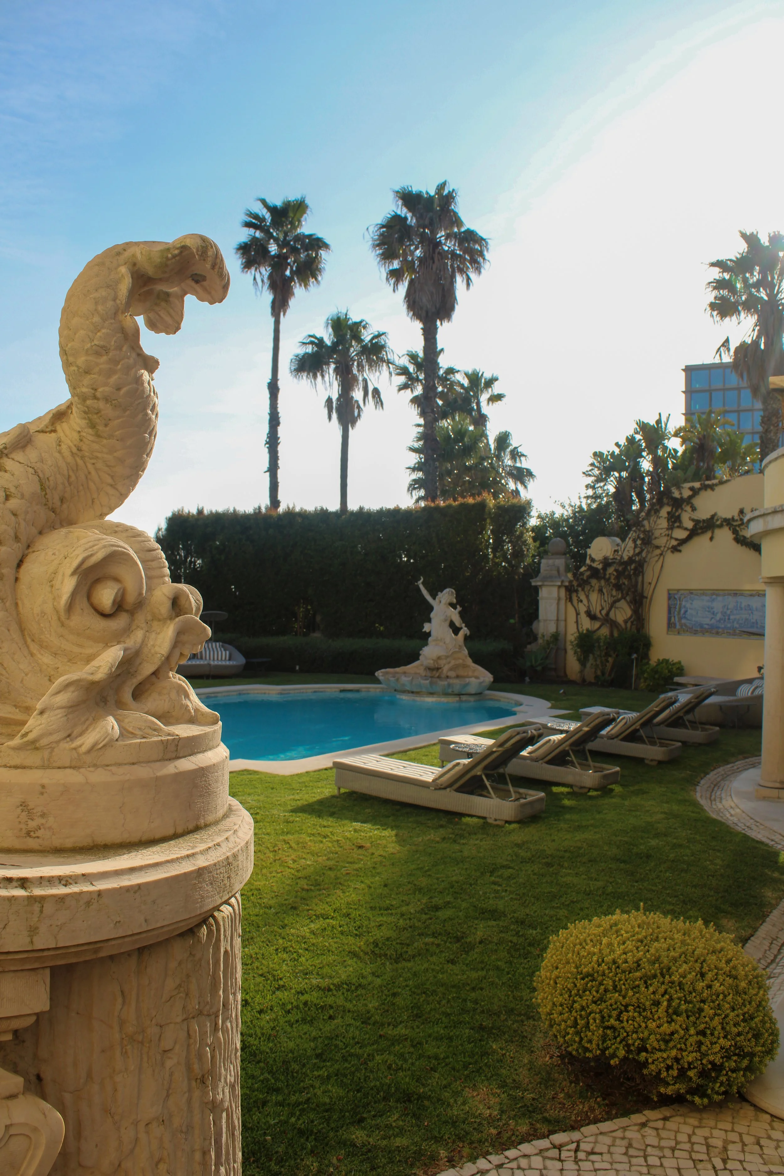 Classical sculptures overlook the peaceful garden and outdoor swimming pool