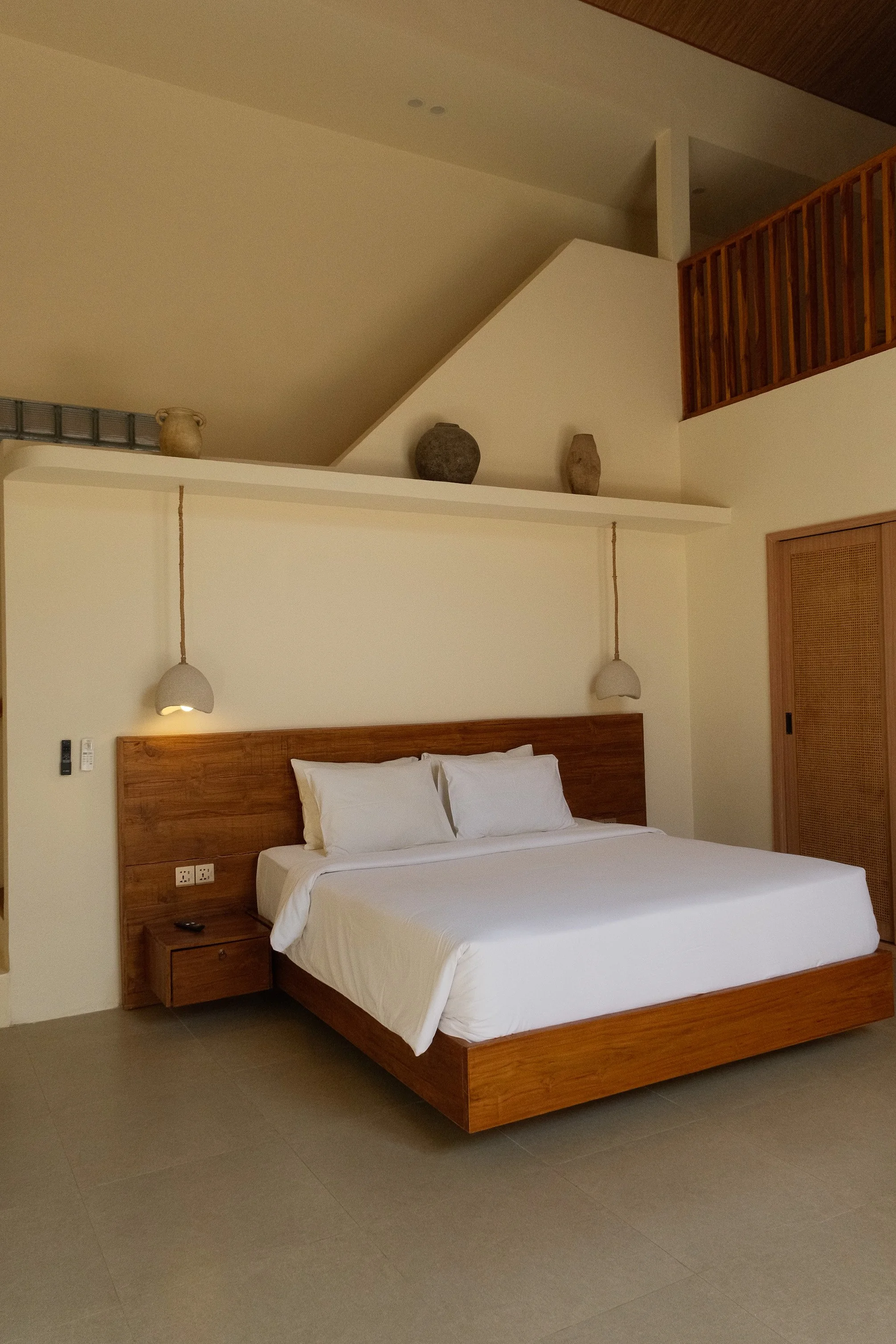 Spacious villa bedroom with soaring ceilings and natural wood accents