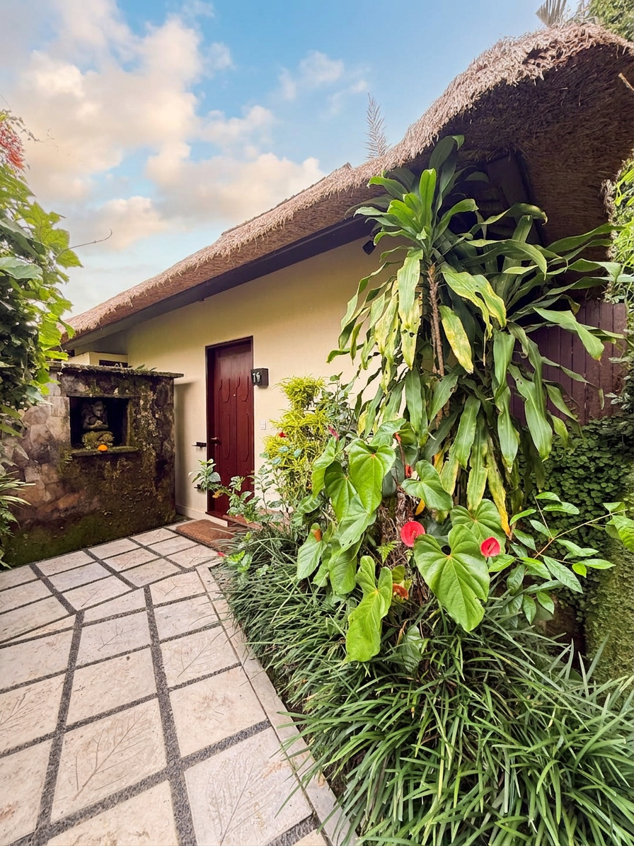 A private villa entrance welcomes guests through tropical gardens inspired by traditional Balinese architecture