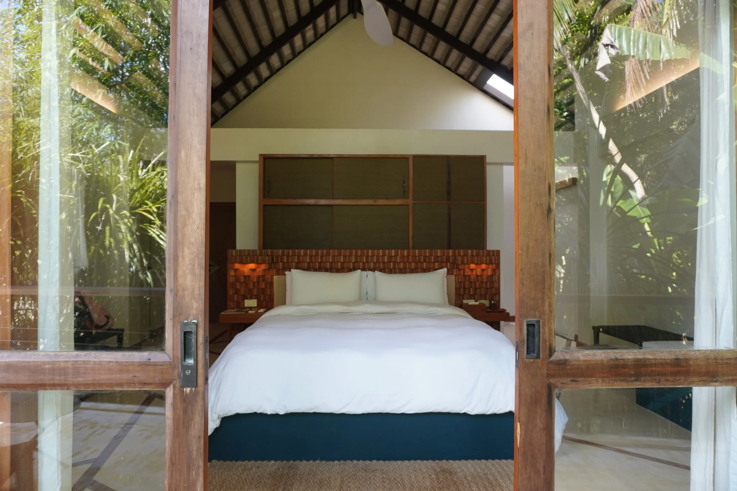 Spacious villa bedroom with vaulted ceilings, handcrafted wooden details, and abundant natural light