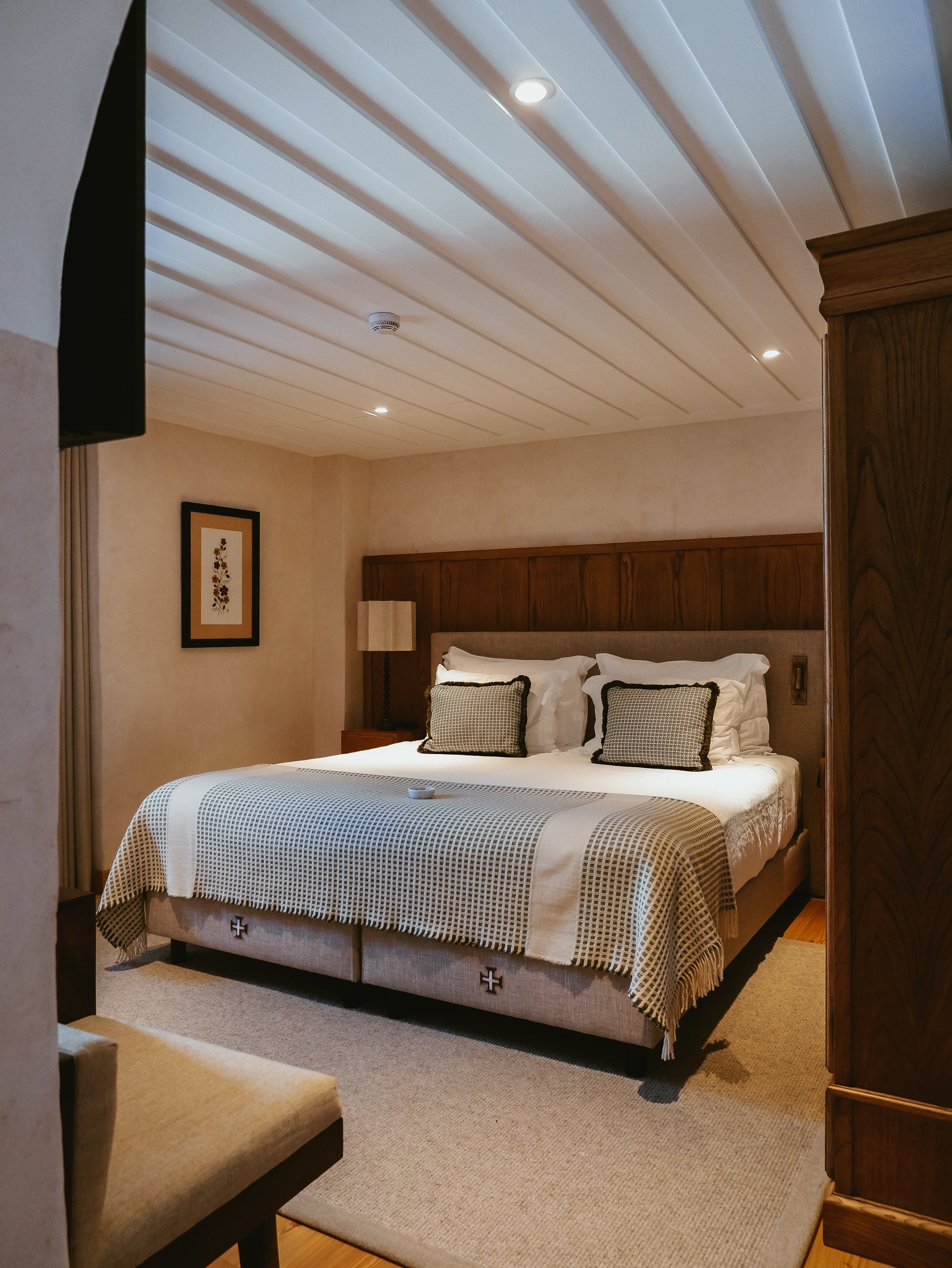 Elegant guest room with warm wood details, neutral textiles, and traditional Portuguese character