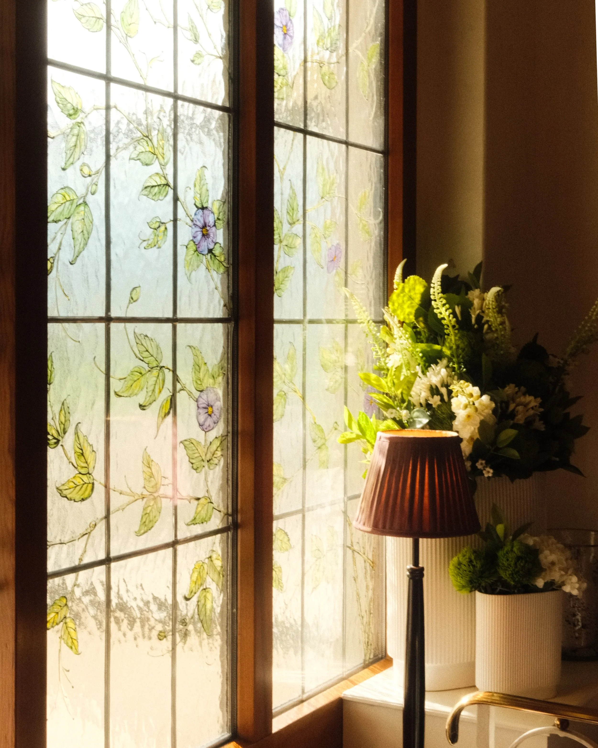 Decorative stained glass window illuminated by warm afternoon sunlight