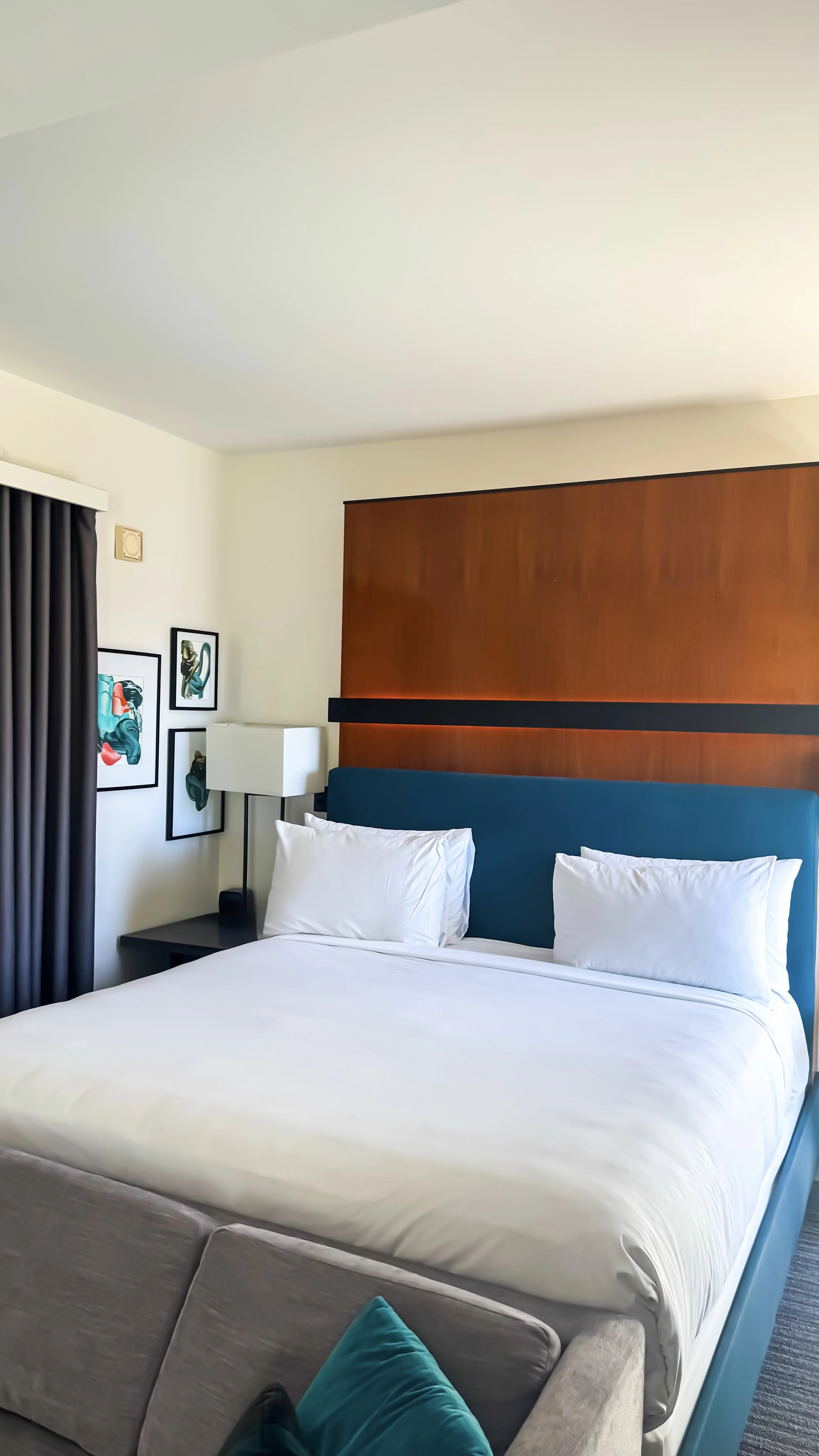 Modern guest room featuring a king-size bed, contemporary artwork, and warm minimalist interiors