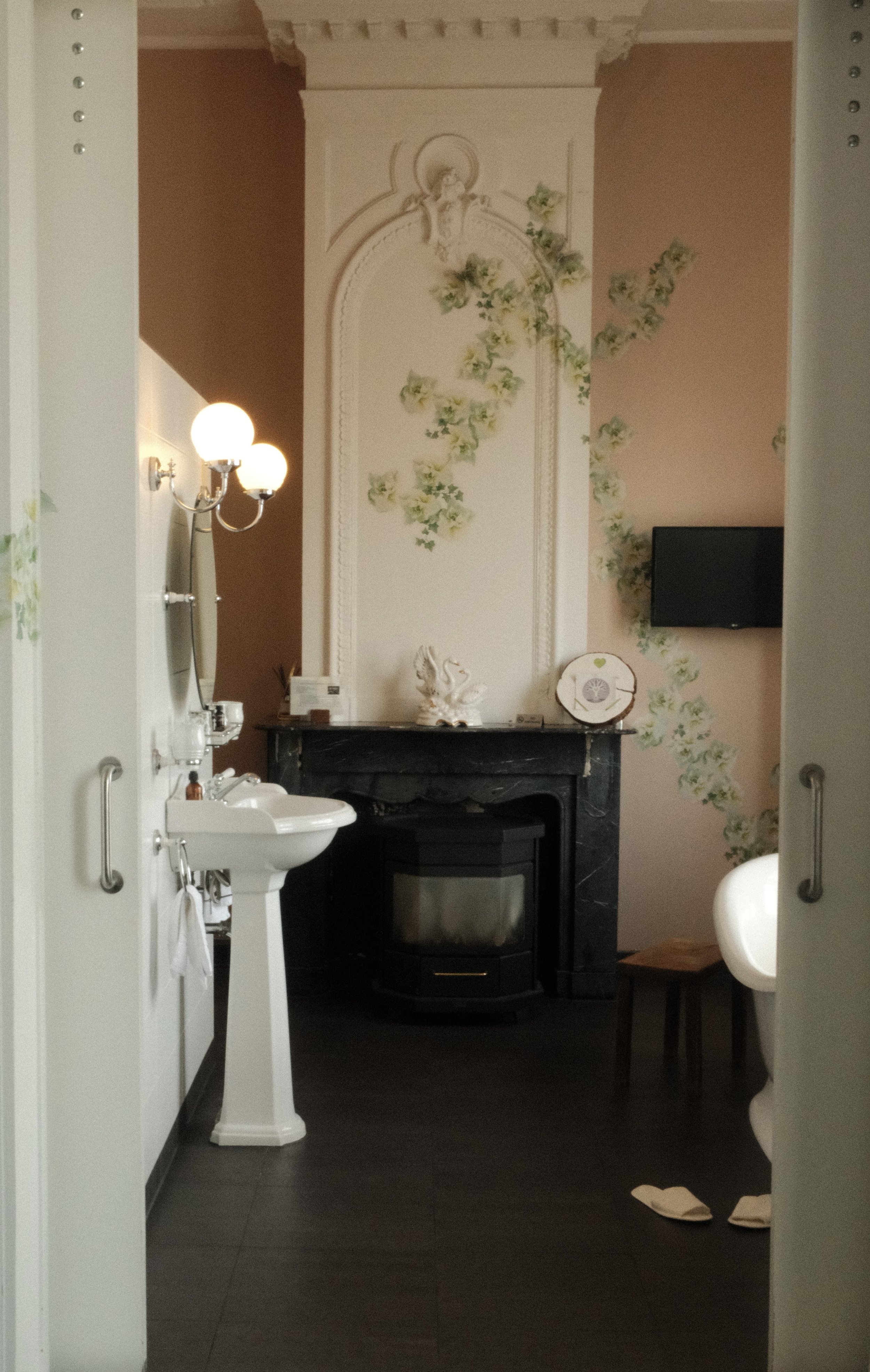 Vintage-style bathroom with freestanding bathtub, fireplace, and classic decor at Suite Hotel Pincoffs Rotterdam