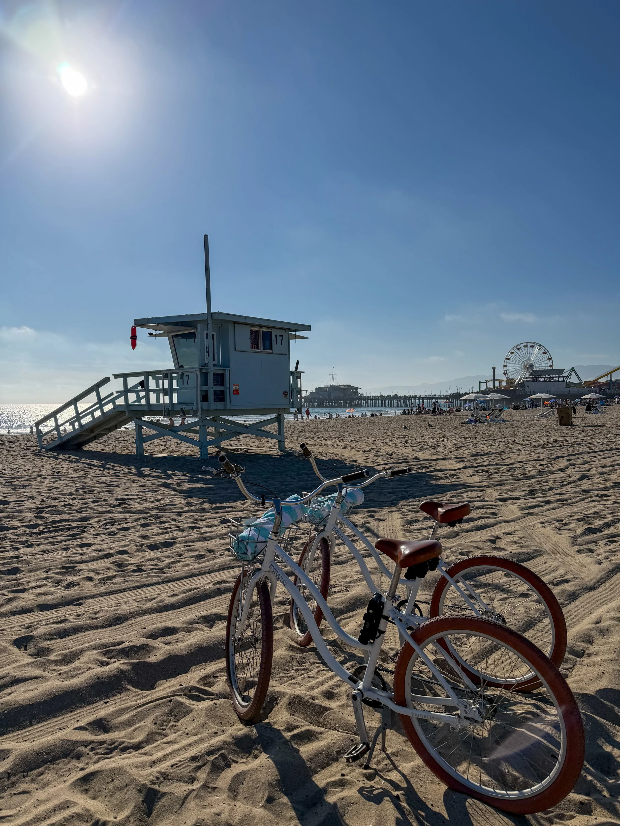 Beach cruiser bicycles on the sand near the Santa Monica Pier, perfect for exploring the California coastline