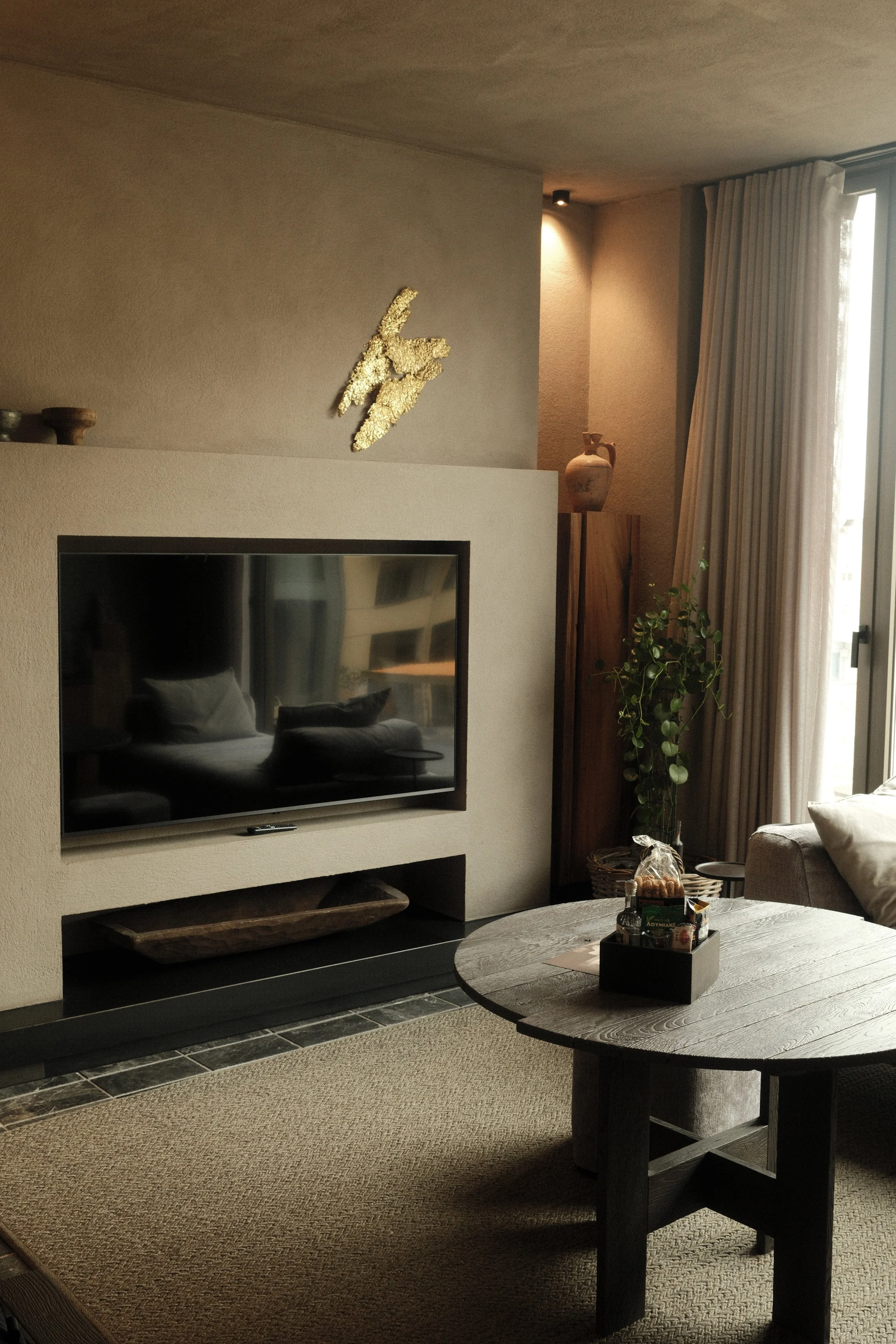 Modern suite living area with textured interiors, curated artwork, and floor-to-ceiling windows
