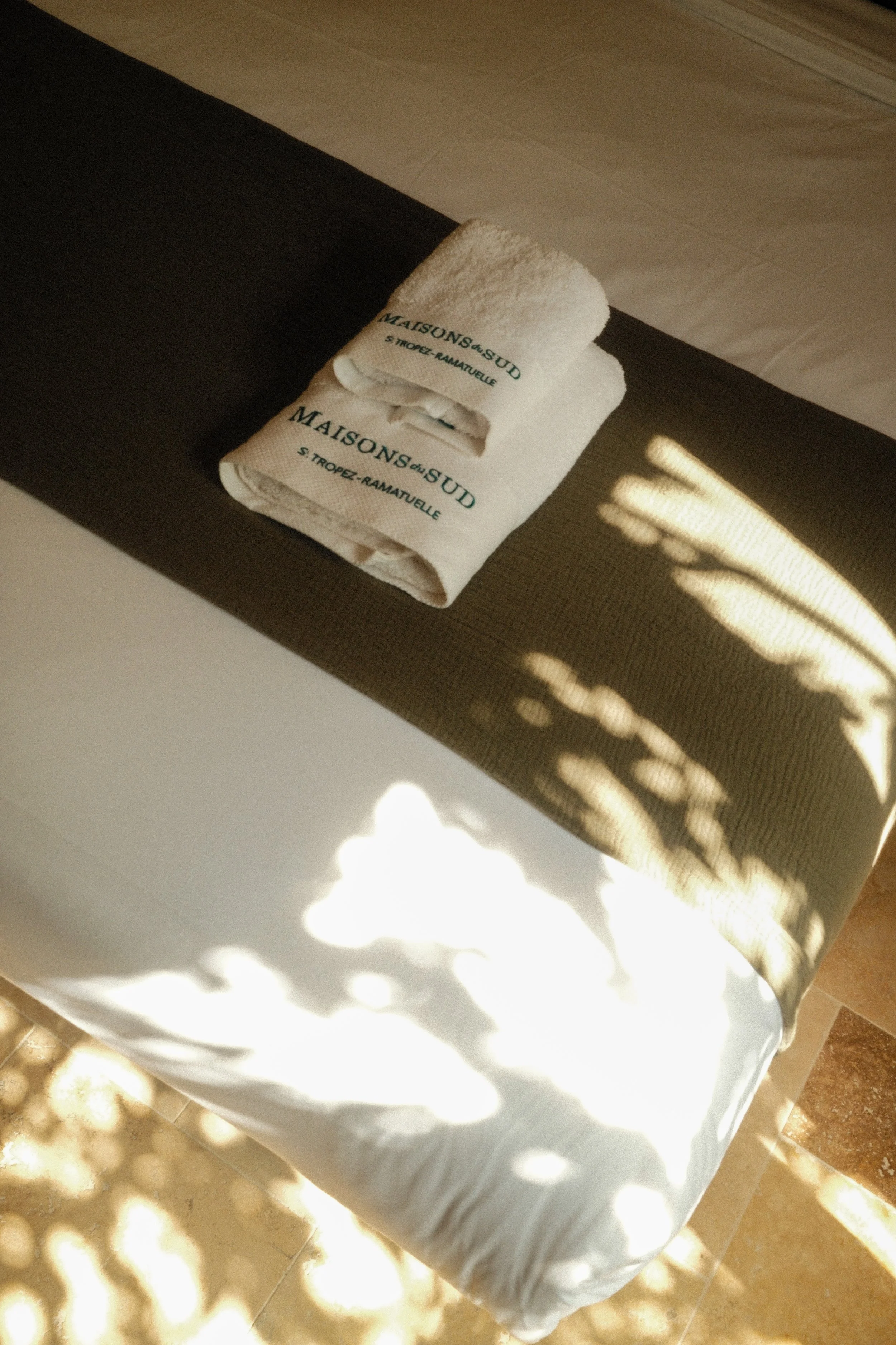 Sunlit bedroom with luxury linens and elegant Mediterranean details
