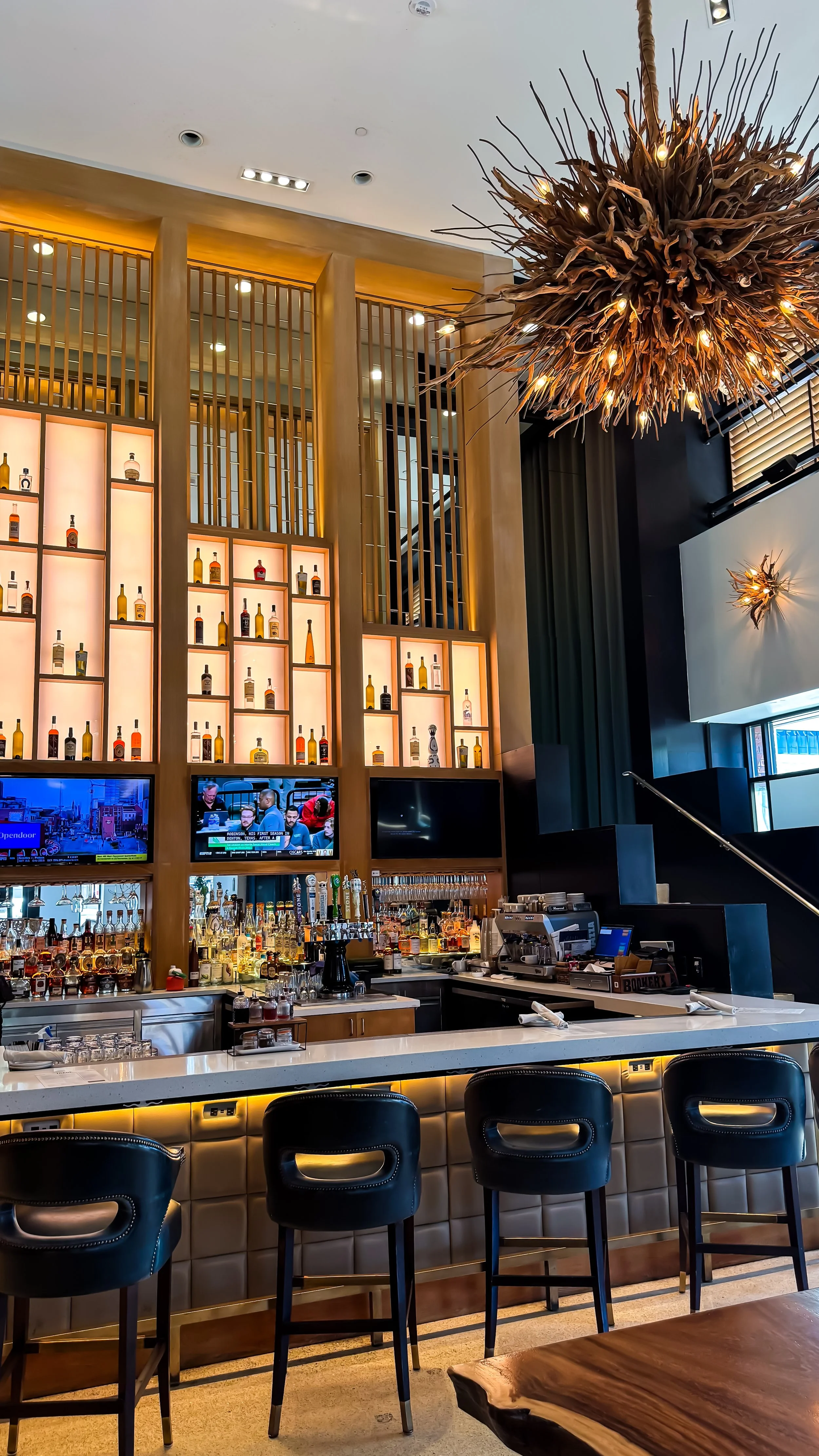 Stylish bar with illuminated backlit shelves, curated spirits display, and contemporary seating design, Hotel Republic San Diego – San Diego, California.