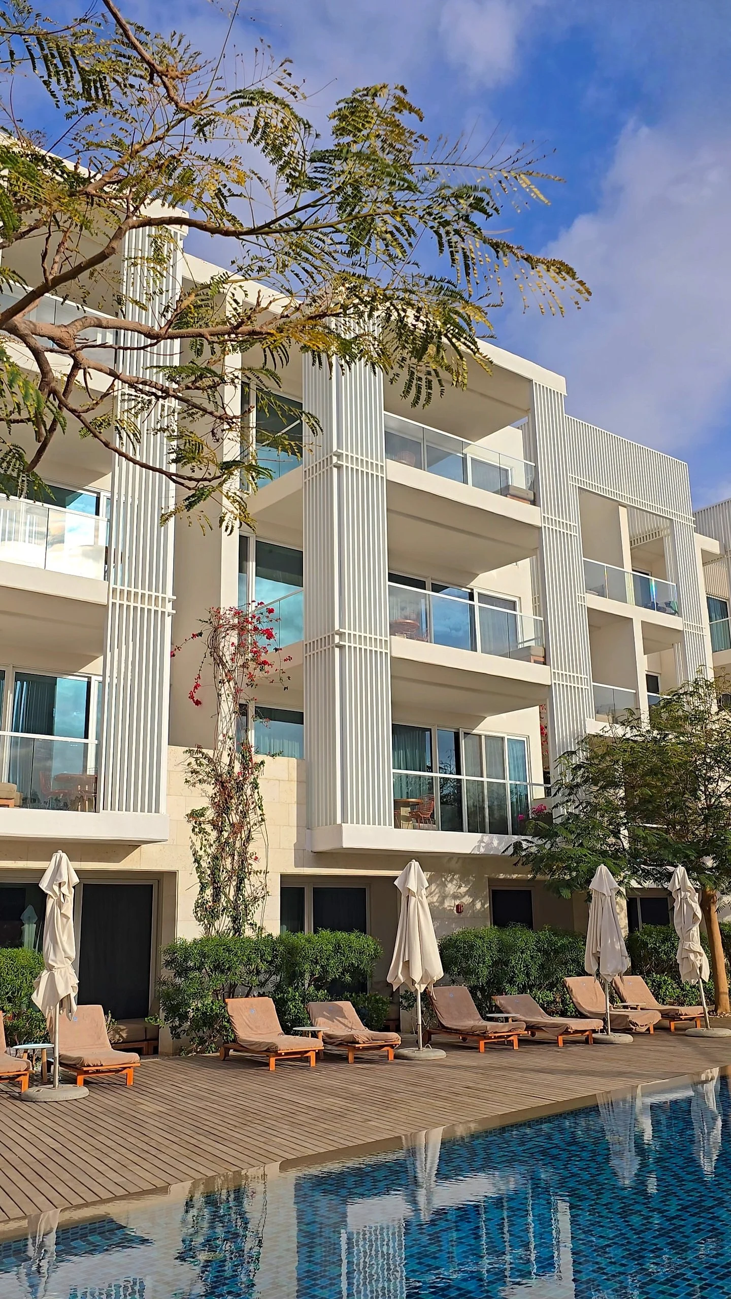 Poolside loungers and private balconies framed by white contemporary architecture, Hyatt Regency Aqaba Ayla Resort – Aqaba, Jordan.