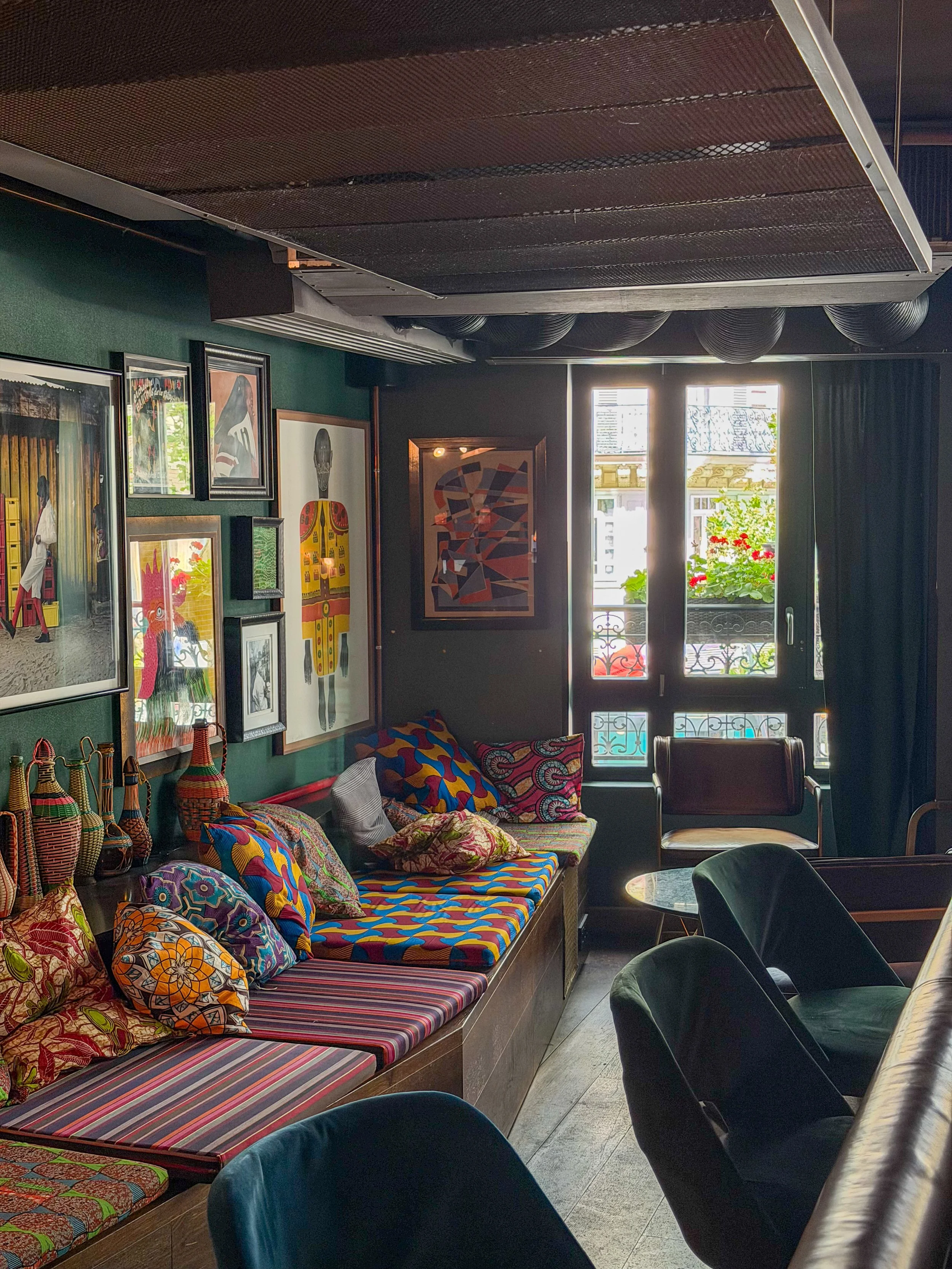 Colorful lounge featuring eclectic décor, vibrant textiles, and contemporary artwork