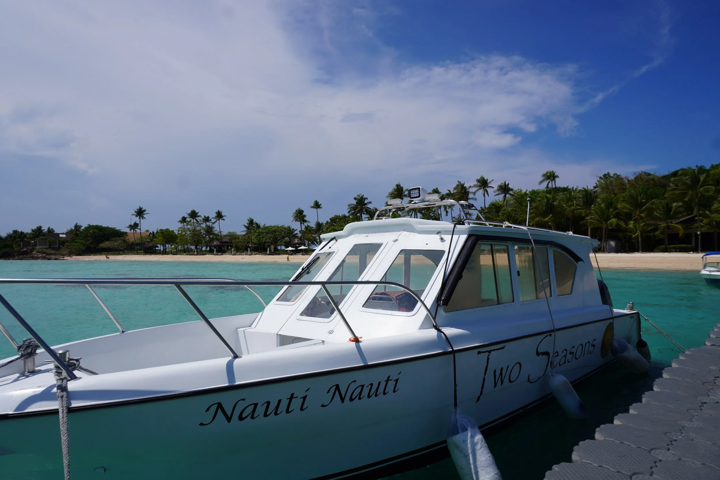 Private speedboat docked beside crystal-clear waters for island-hopping adventures