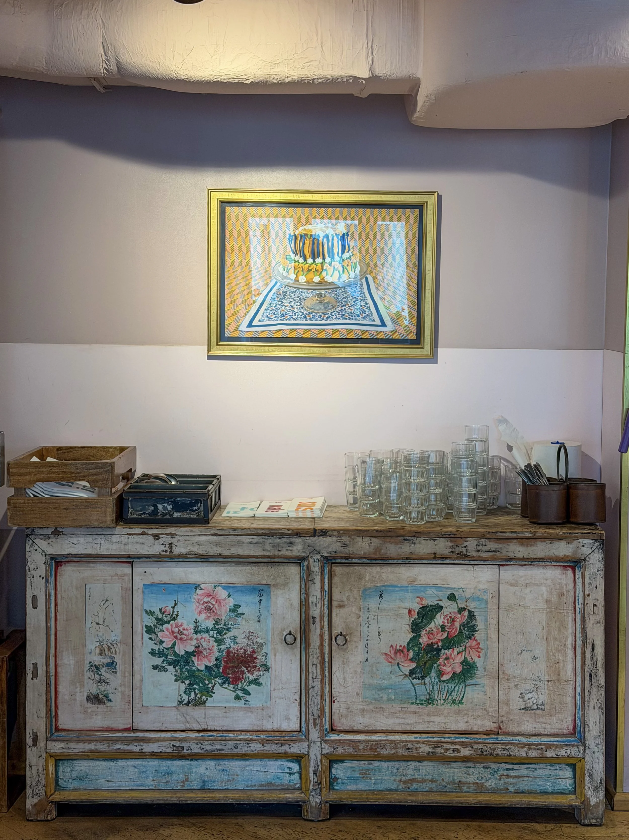 Vintage sideboard decorated with floral artwork and handcrafted design elements