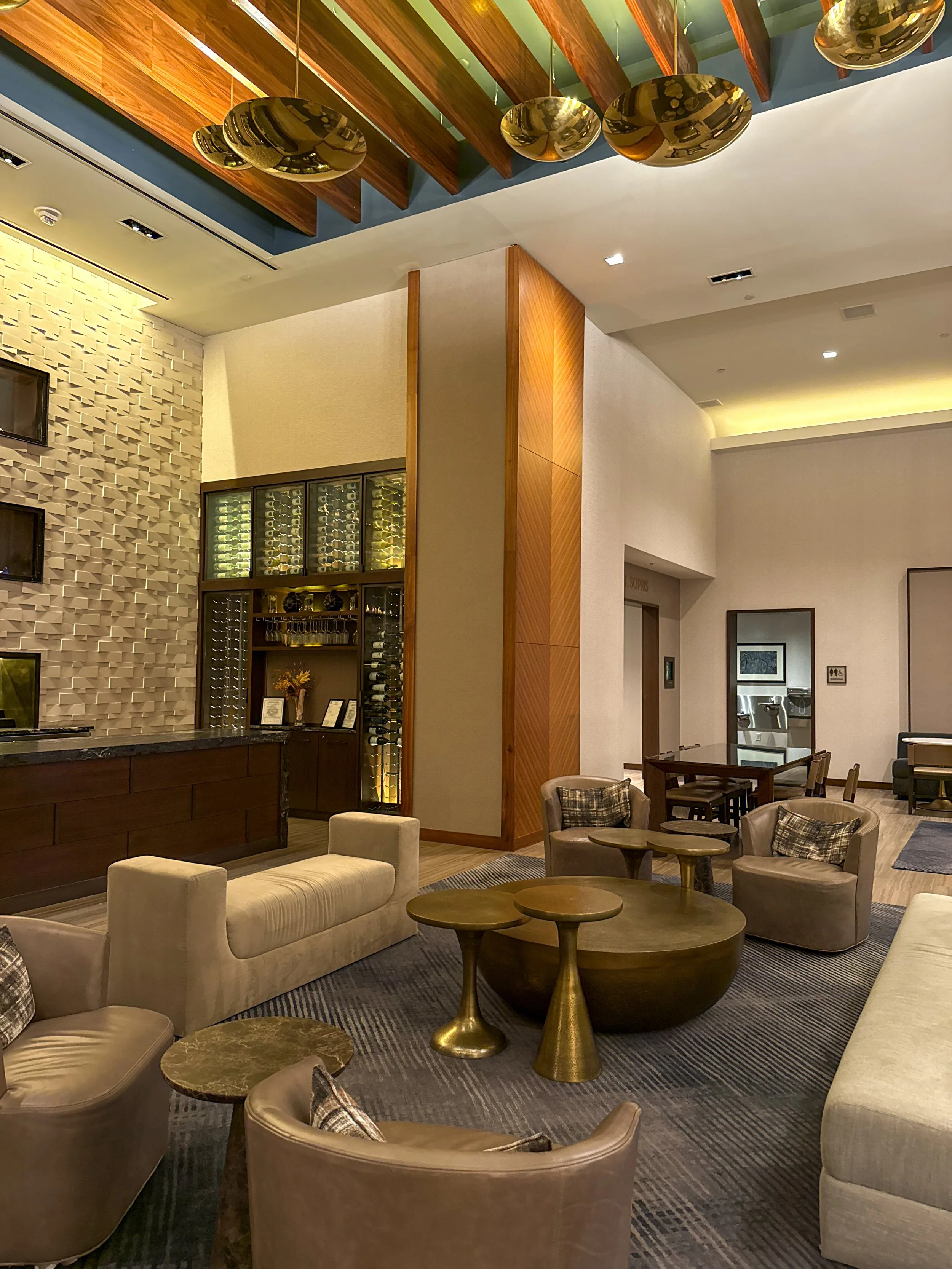 Spacious hotel lobby with modern seating, wood accents, and sculptural pendant lights