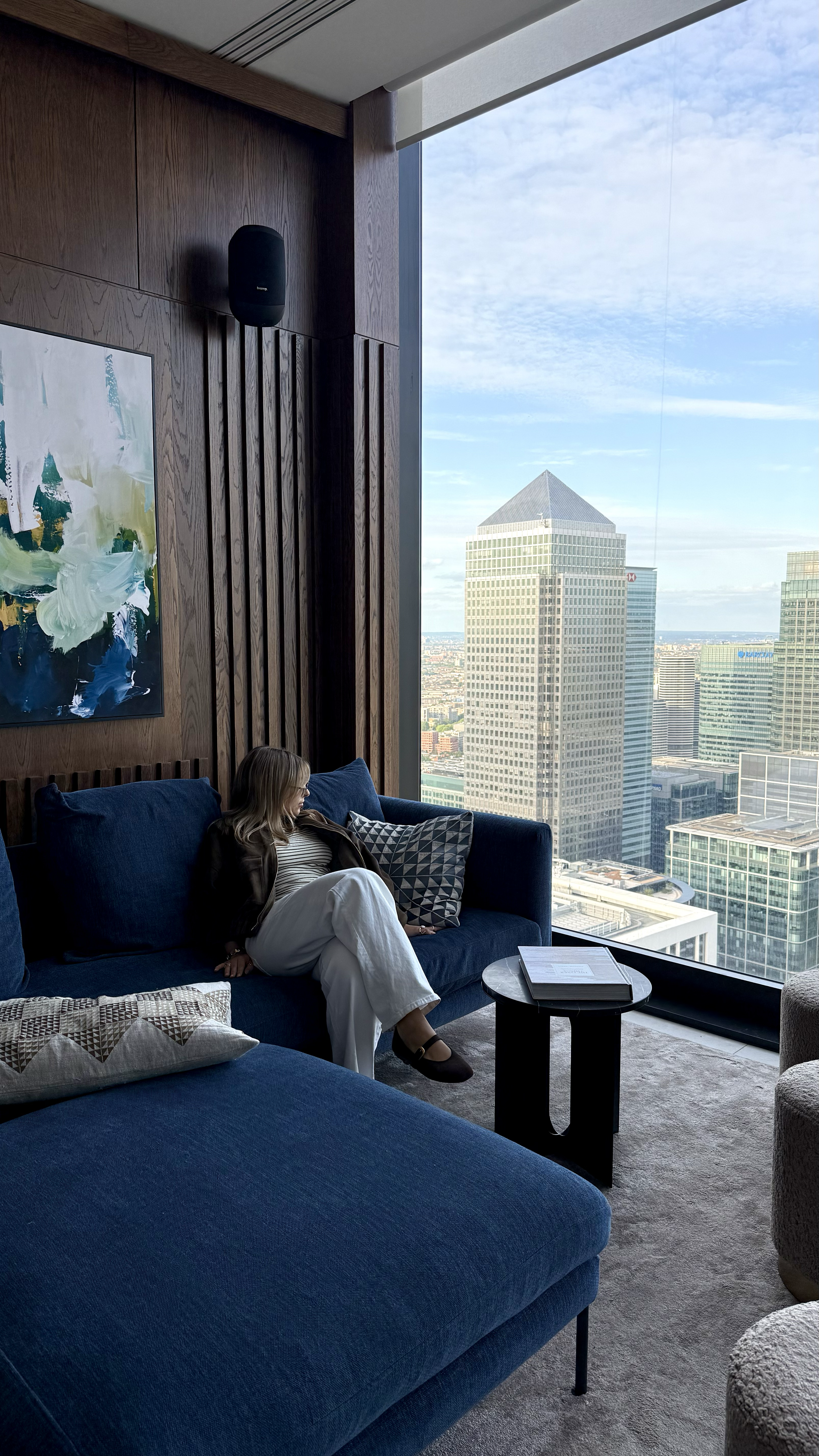 Guest relaxing in a stylish lounge with panoramic Canary Wharf skyline views
