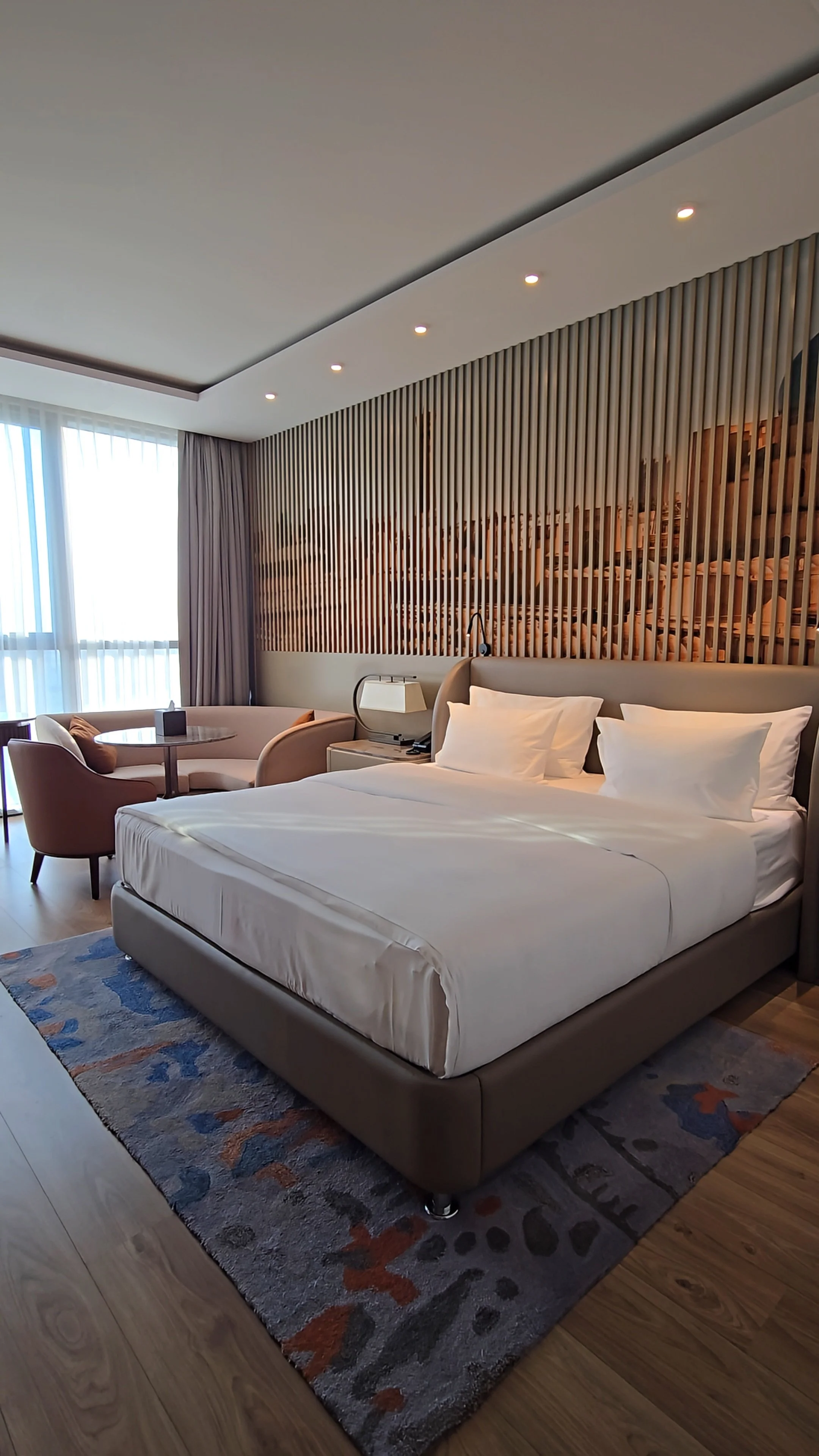 Spacious luxury guest room with a king-size bed, elegant furnishings, and modern comforts