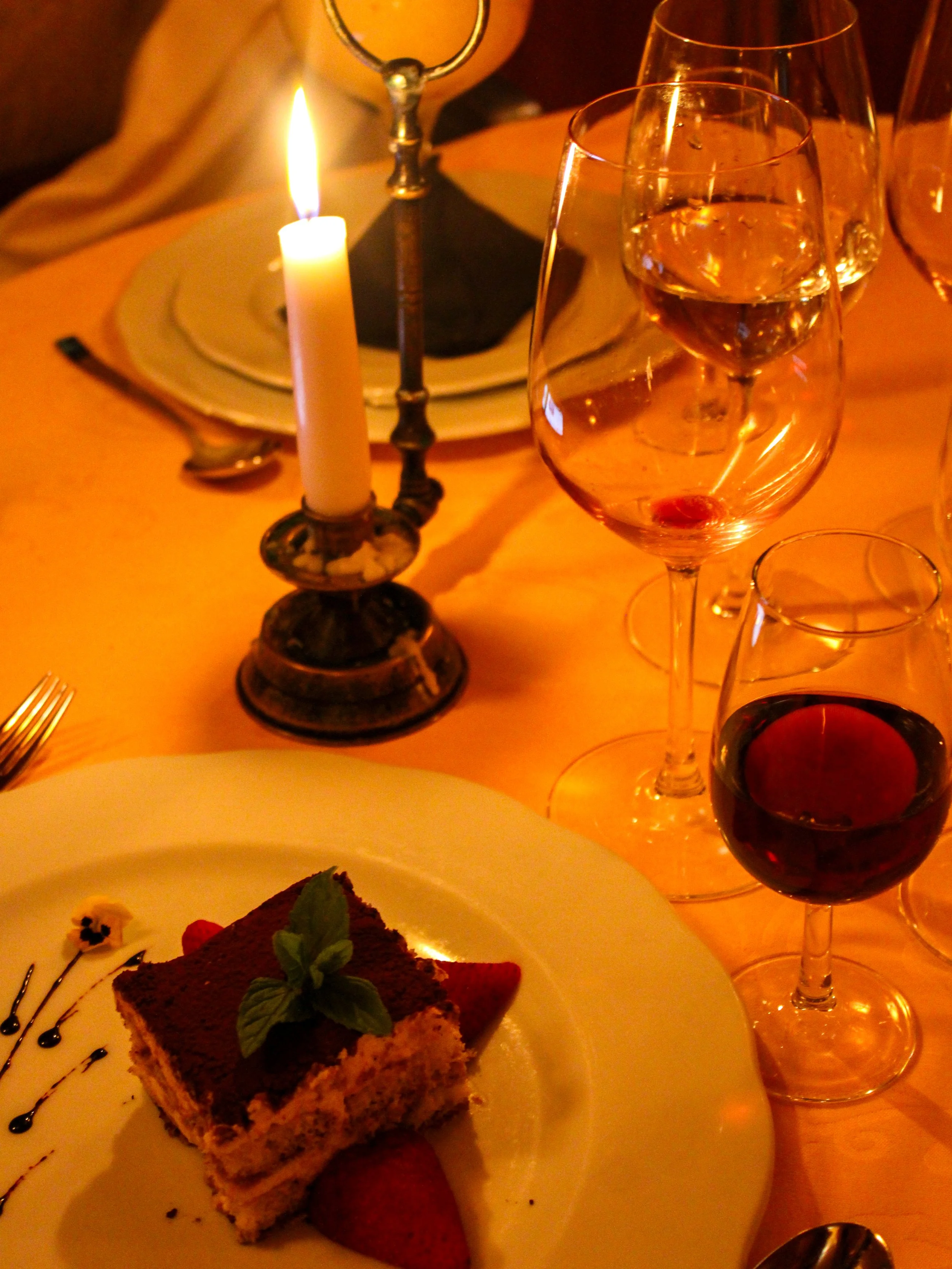 Artisan dessert served alongside premium Portuguese wines in a romantic candlelit setting