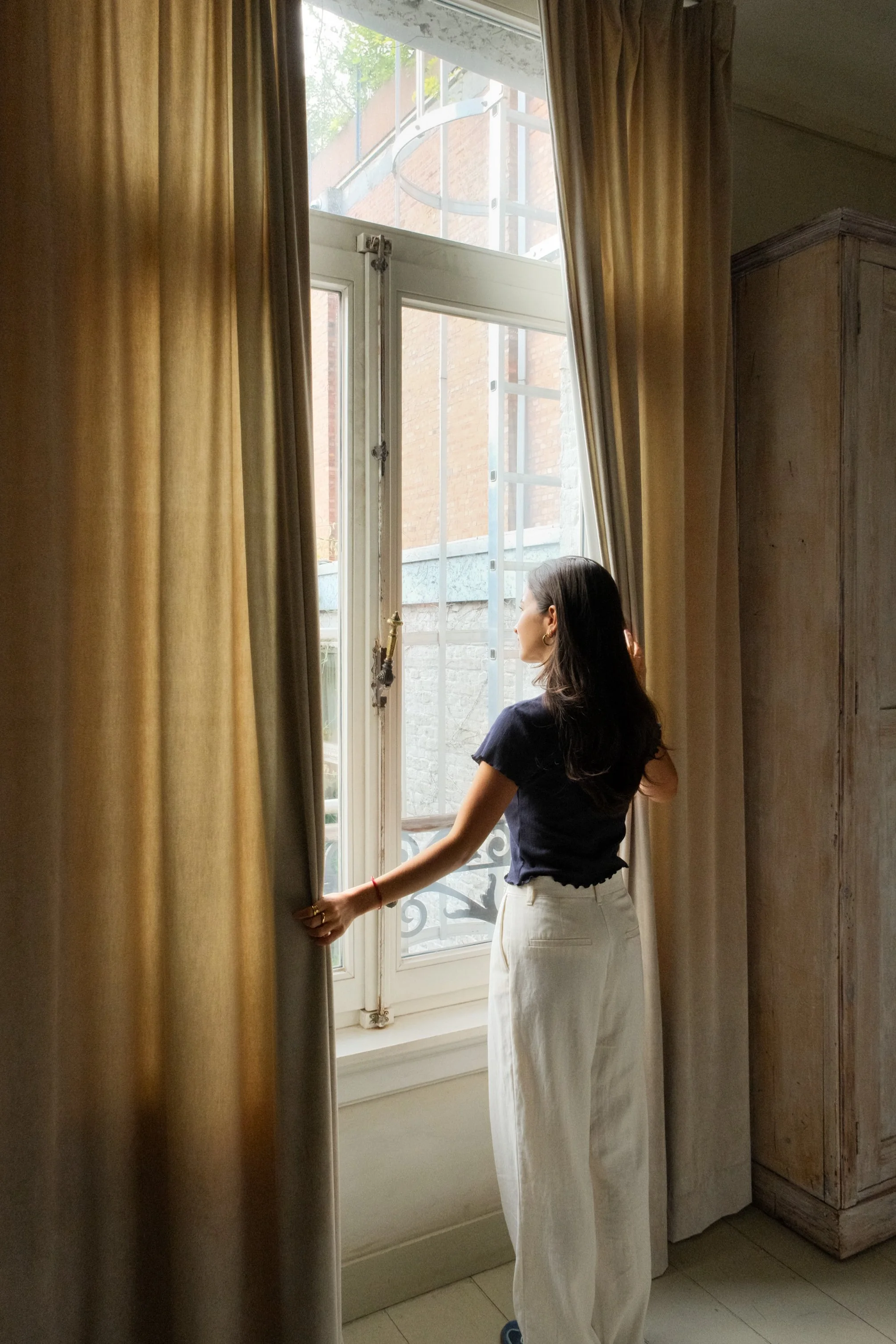 Guest enjoying natural light beside large historic windows