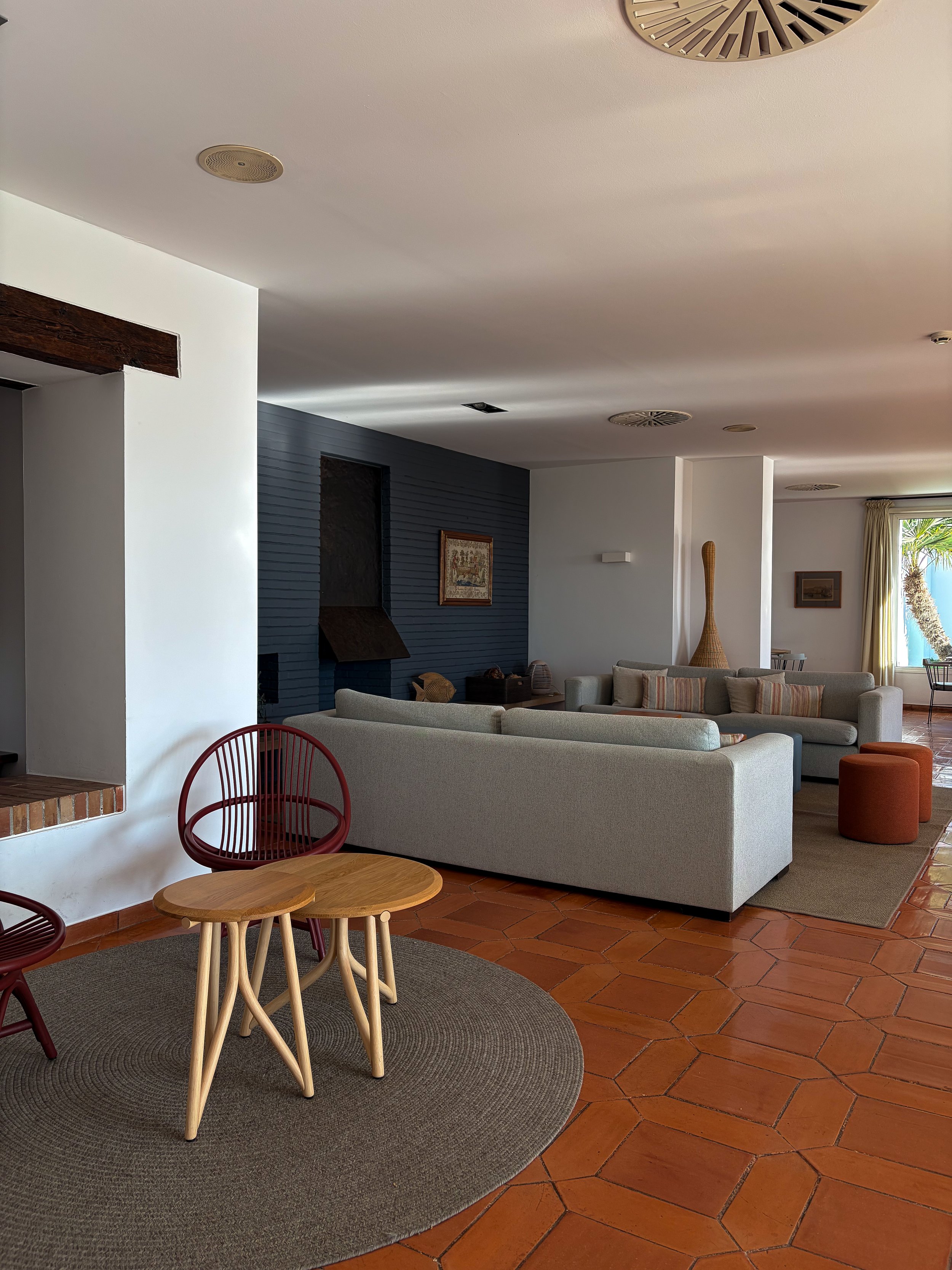 Relaxed lounge with terracotta flooring, soft seating, and understated decor