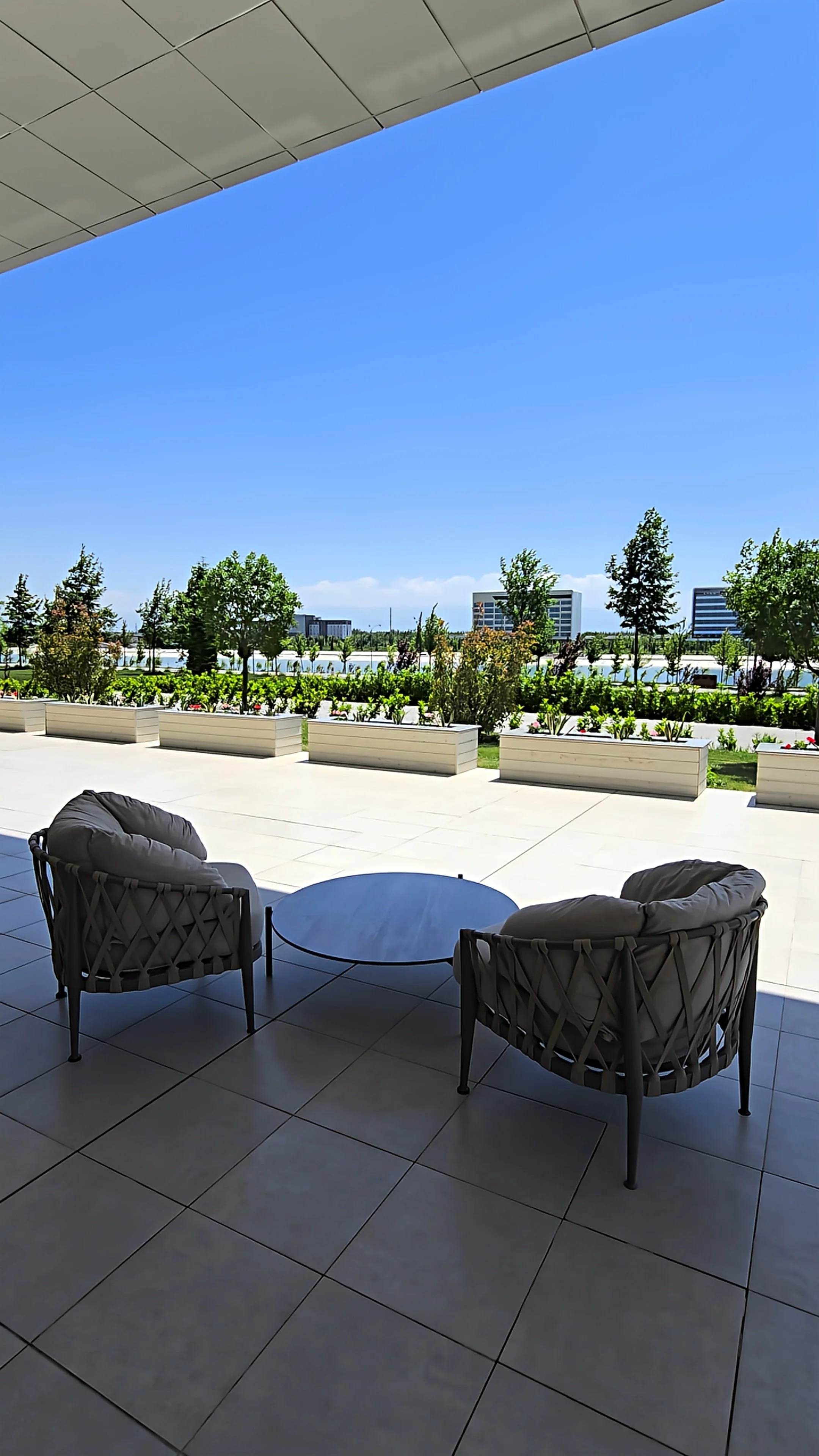 Outdoor terrace overlooking landscaped gardens with comfortable seating and peaceful surroundings