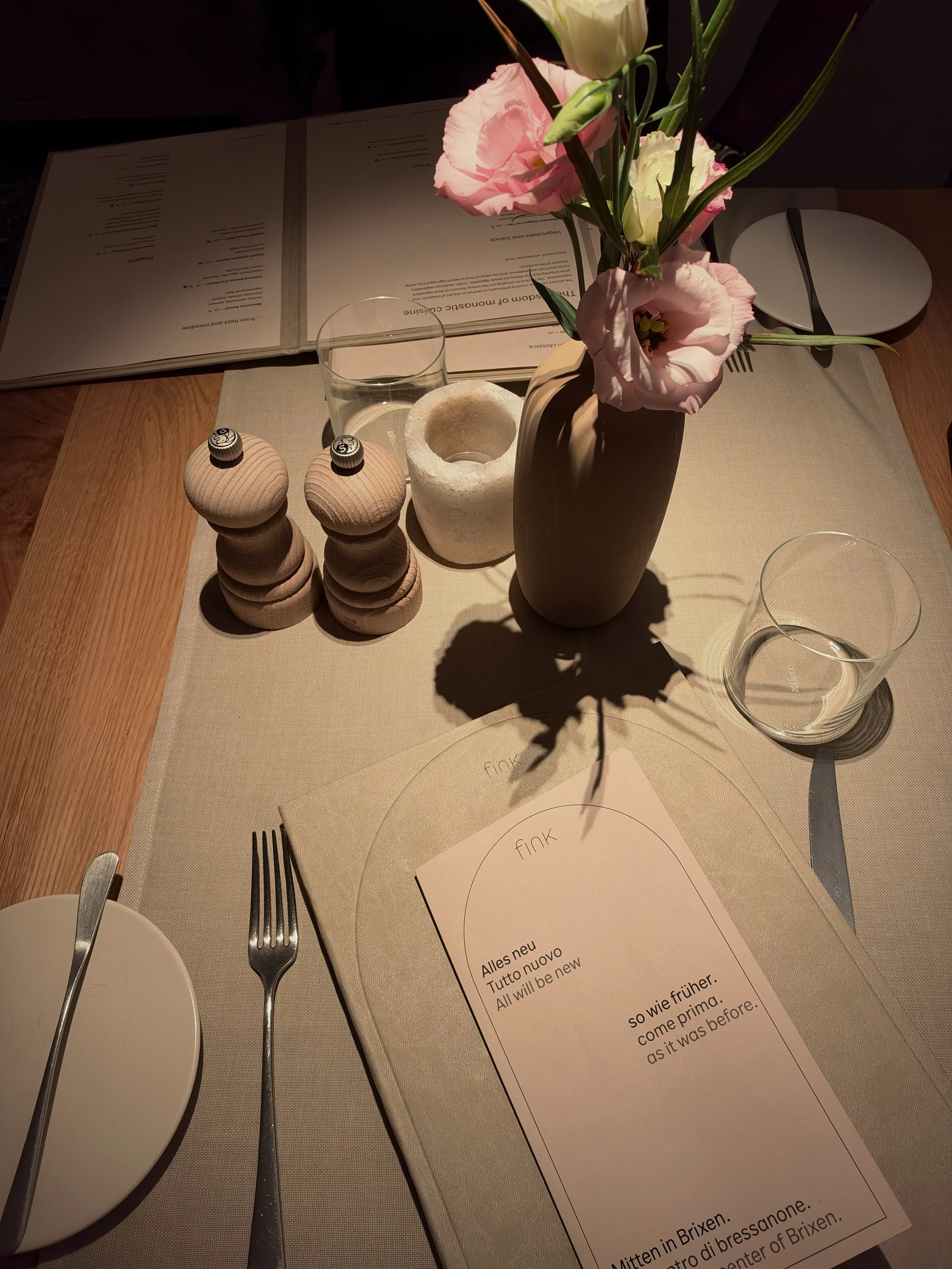 Elegant restaurant table setting featuring fresh flowers, natural wood accents, and thoughtfully arranged tableware