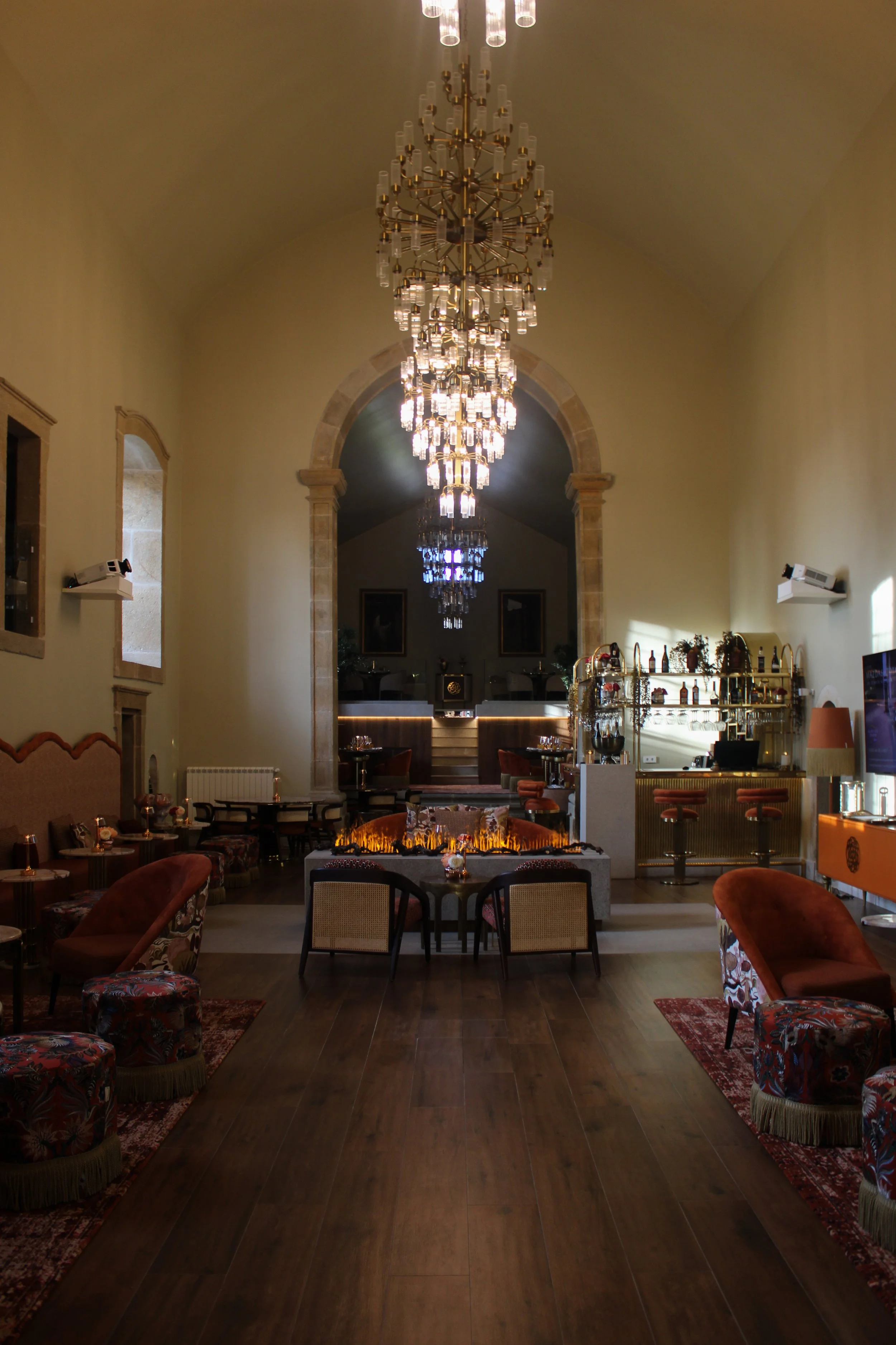 Grand lounge with chandeliers, fireplace, and refined contemporary furnishings