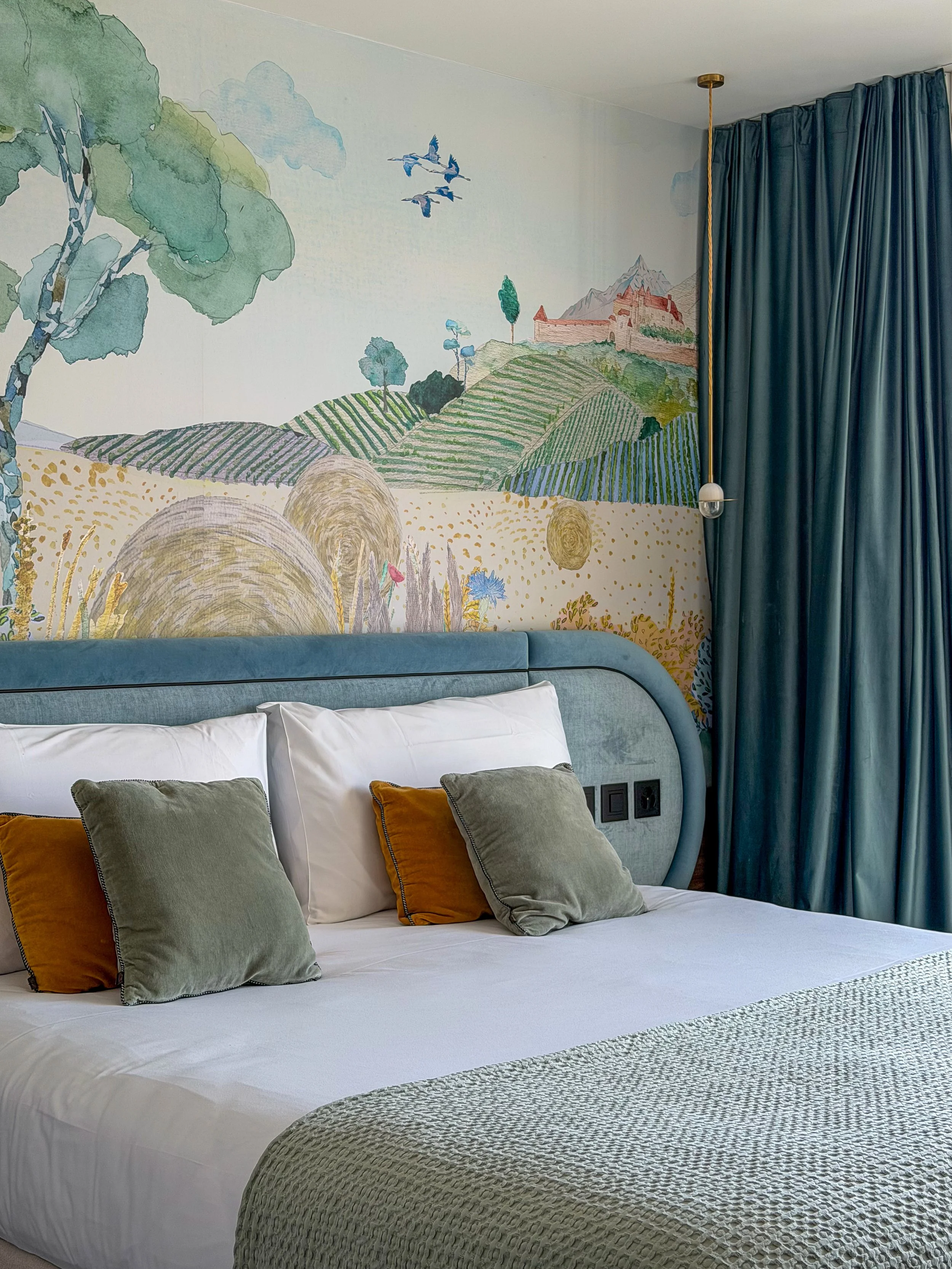 Contemporary bedroom with a handcrafted mural inspired by the landscapes of the Gruyère region