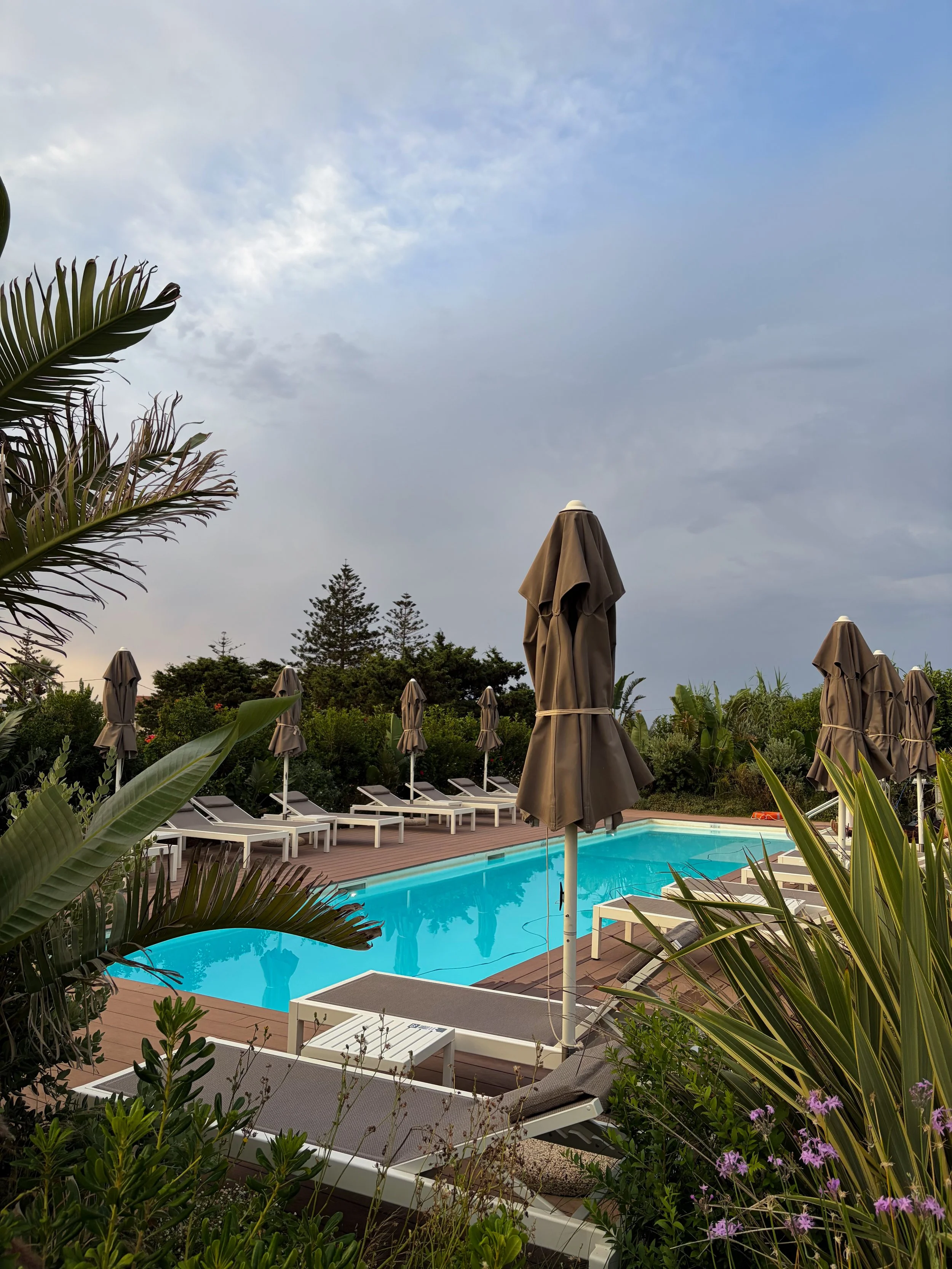 Quiet outdoor swimming pool surrounded by lush Mediterranean gardens