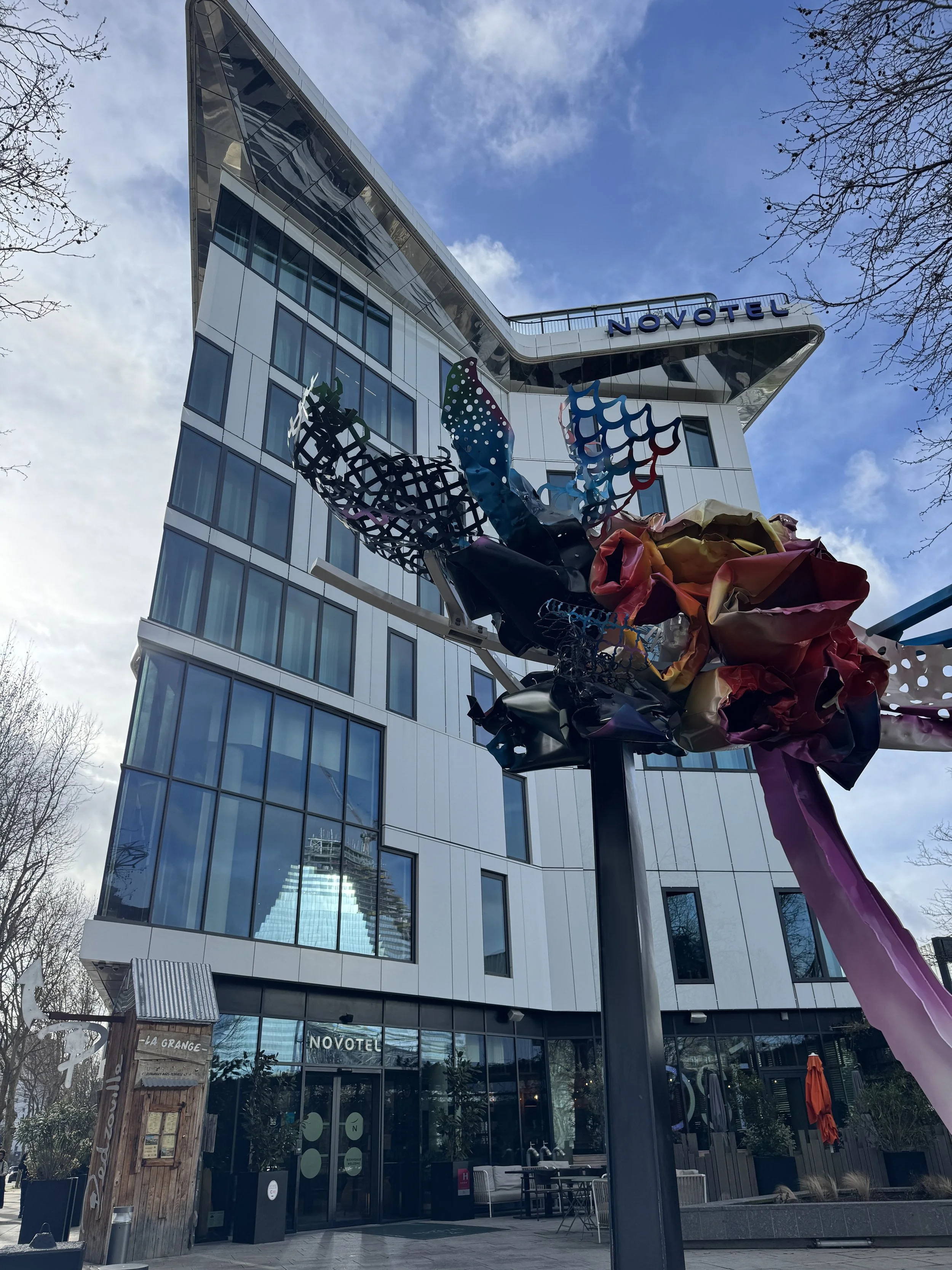 Contemporary façade with artistic sculpture at the entrance of a modern urban hotel building, Novotel Paris Porte de Versailles – Paris, France.