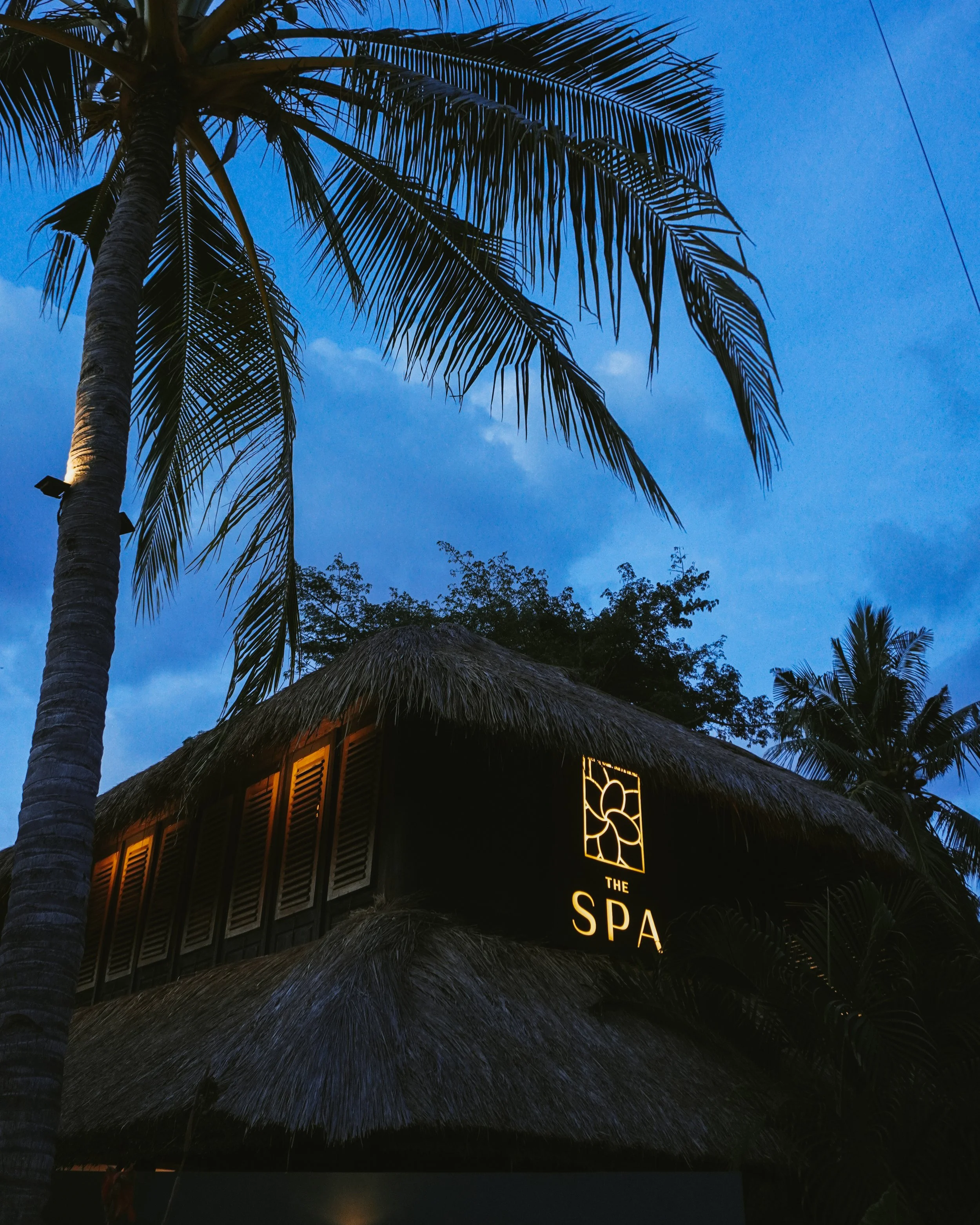 Evening spa exterior with soft lighting and palm silhouettes at Villa Tokay in Gili Air