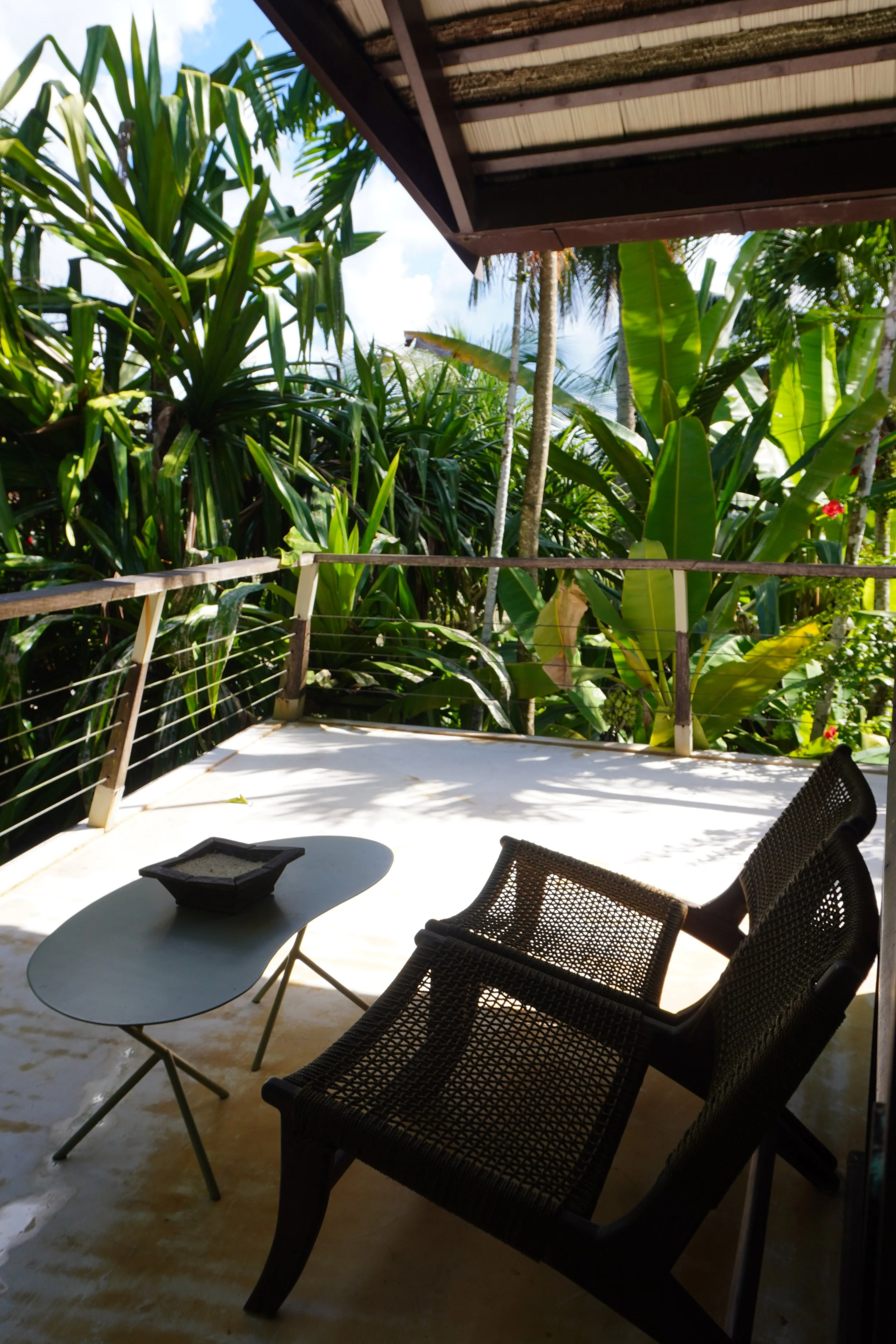 Private outdoor terrace immersed in tropical greenery with comfortable lounge seating