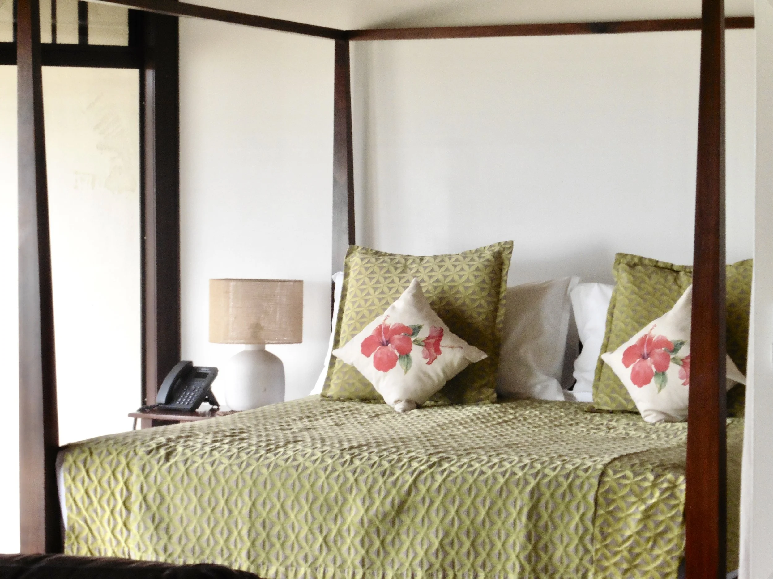 Elegant four-poster bedroom featuring tropical décor and a bright island-inspired atmosphere