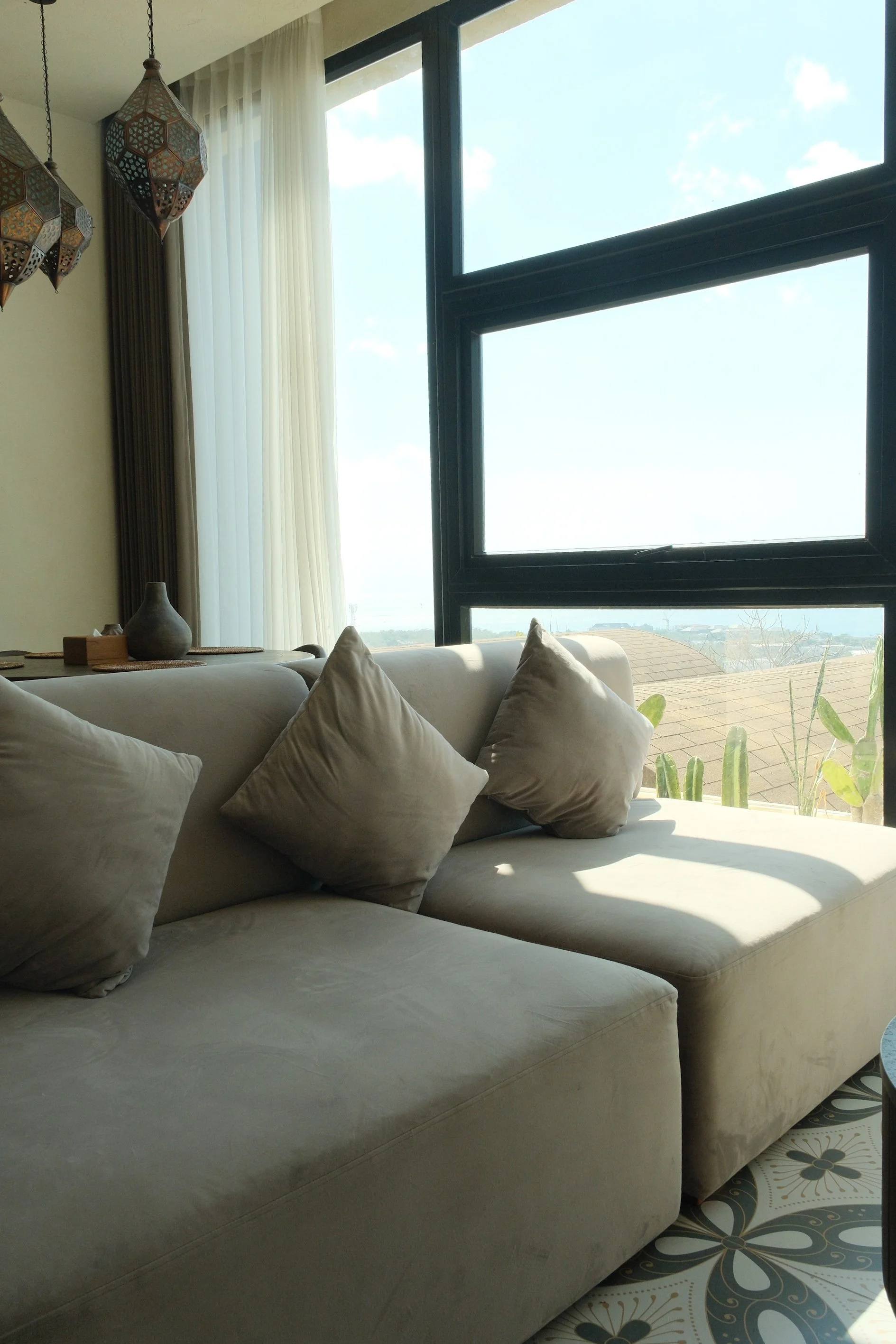 Bright lounge area overlooking Bali's tropical landscape through floor-to-ceiling windows