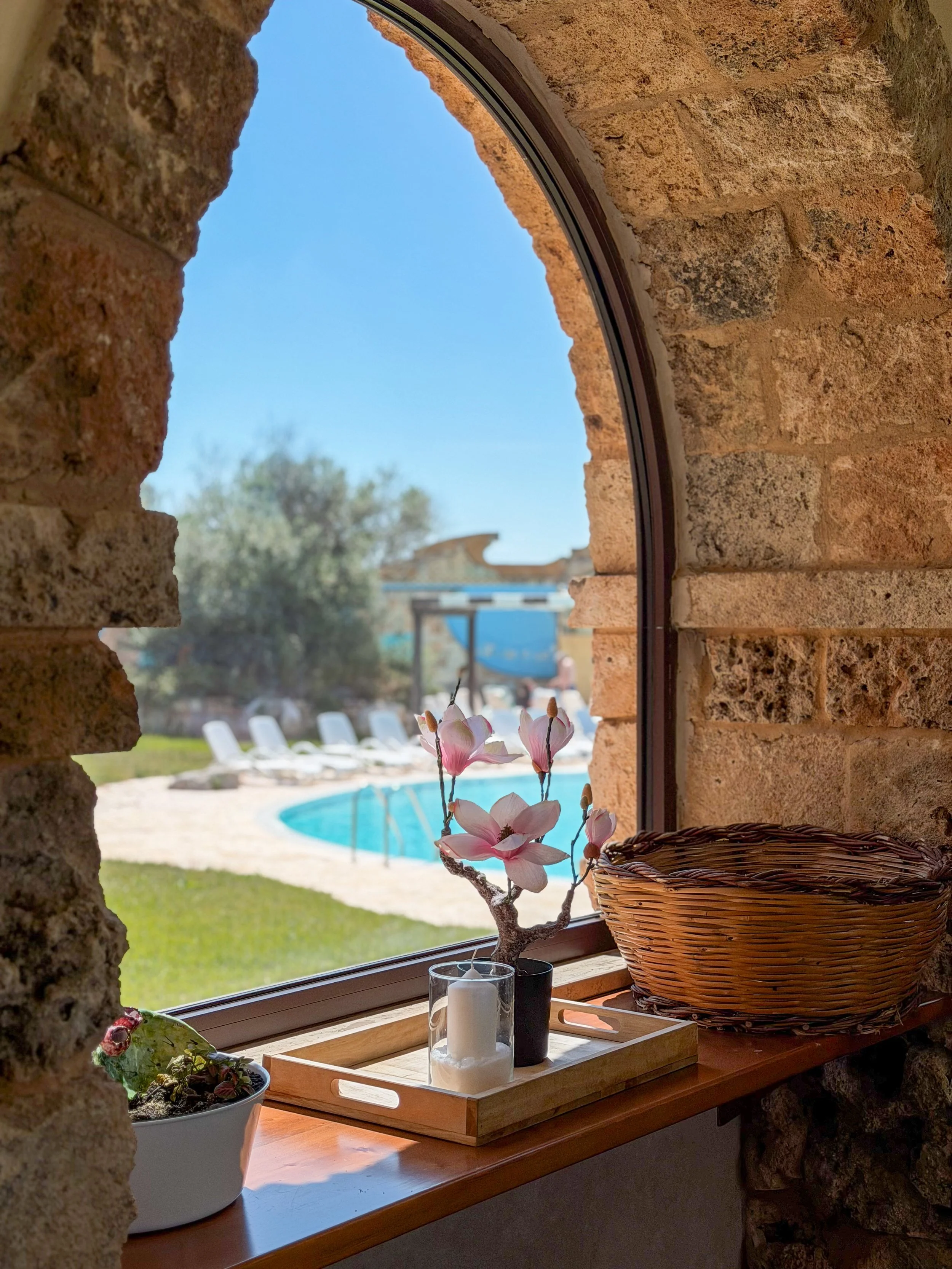 Charming interior window overlooking the resort gardens and pool area at Tenute Al Bano
