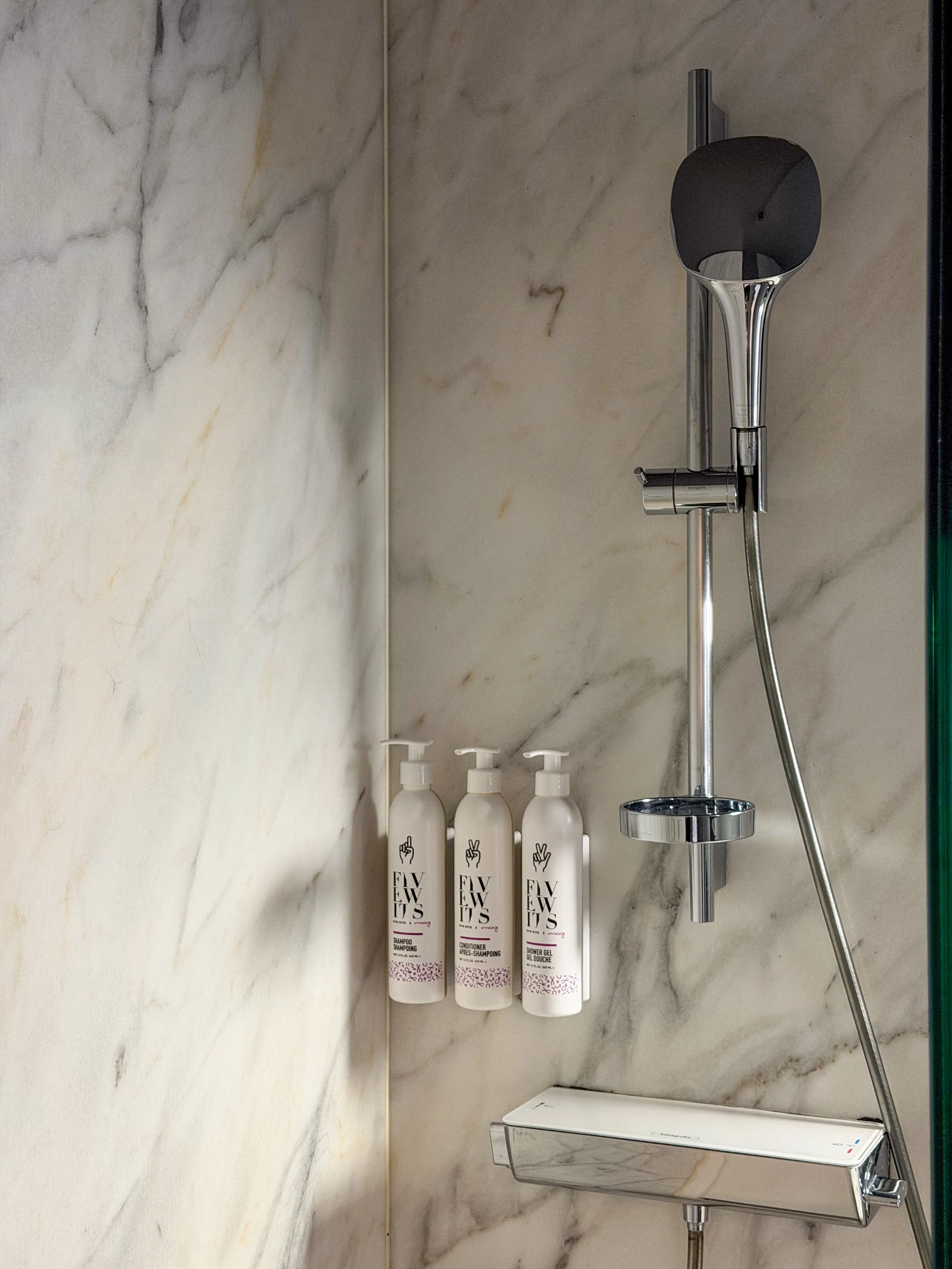 Marble walk-in shower with premium Five Wits toiletries and modern fixtures