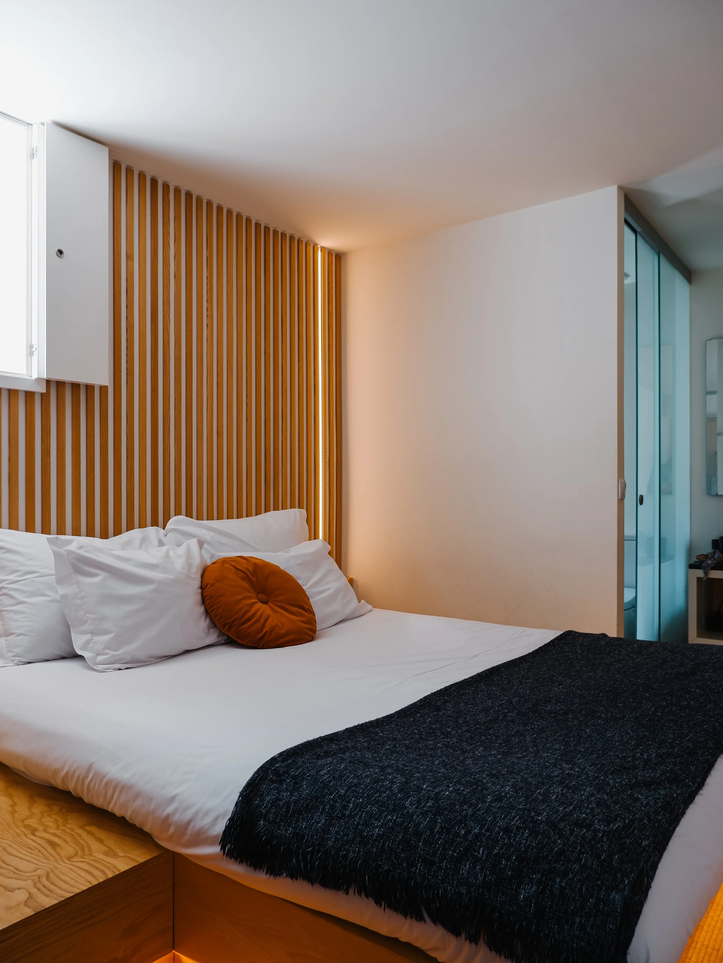 Minimalist Japanese-inspired bedroom with warm wood accents and contemporary boutique design