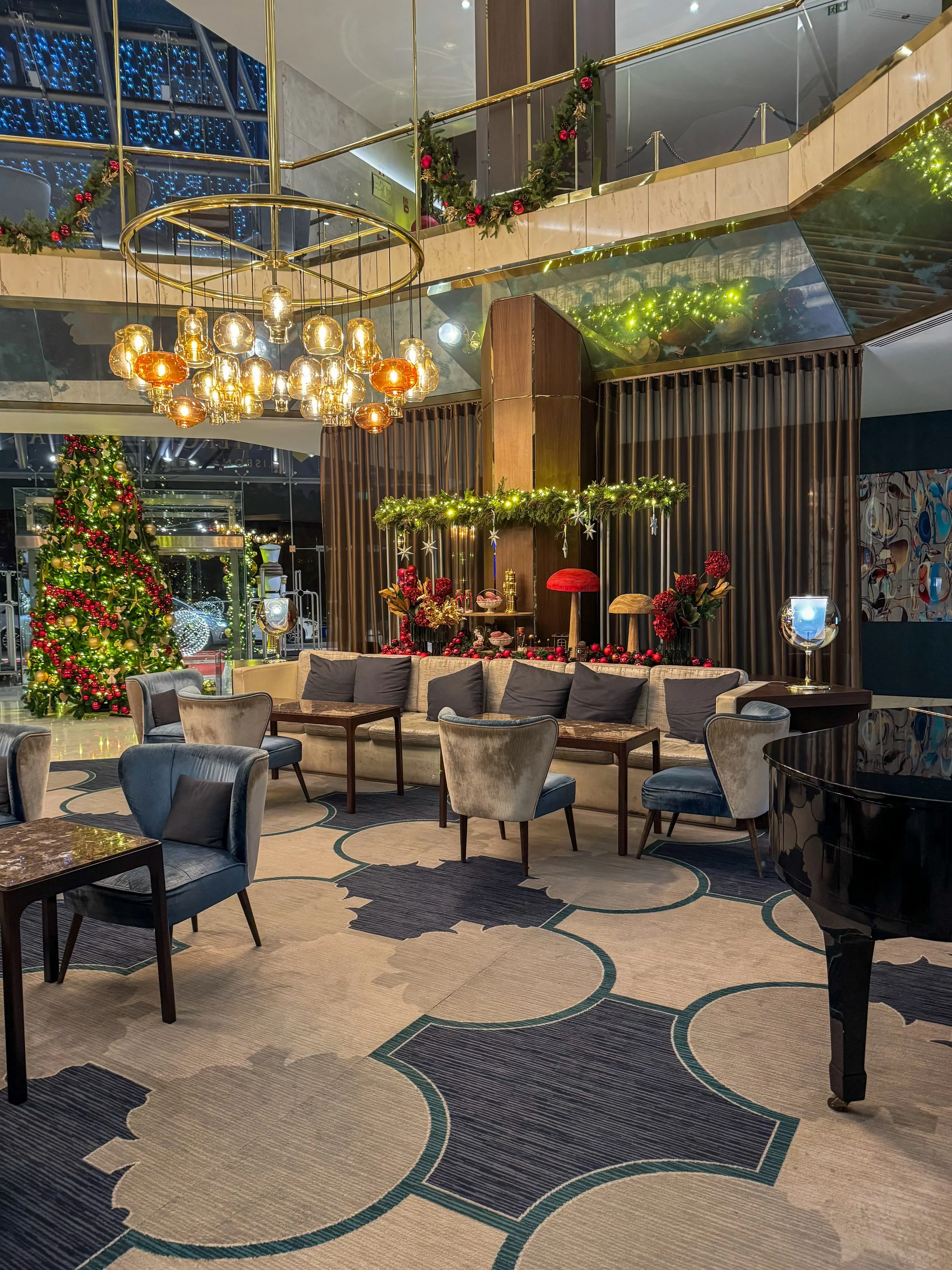 Grand hotel lobby with contemporary design, festive décor, and elegant lounge seating