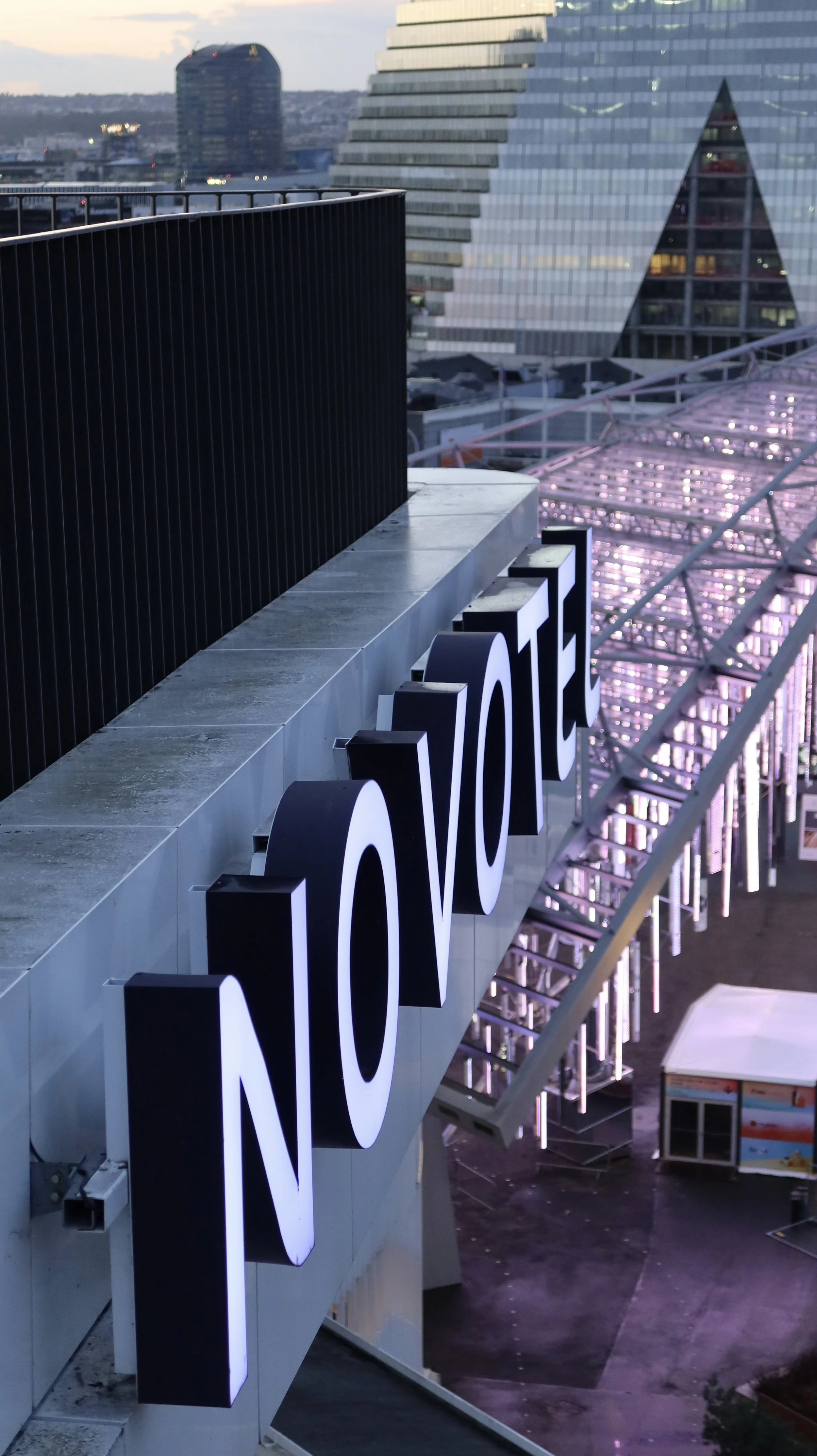 Rooftop view overlooking Paris skyline at dusk with illuminated architecture and modern urban scenery, Novotel Paris Porte de Versailles – Paris, France.