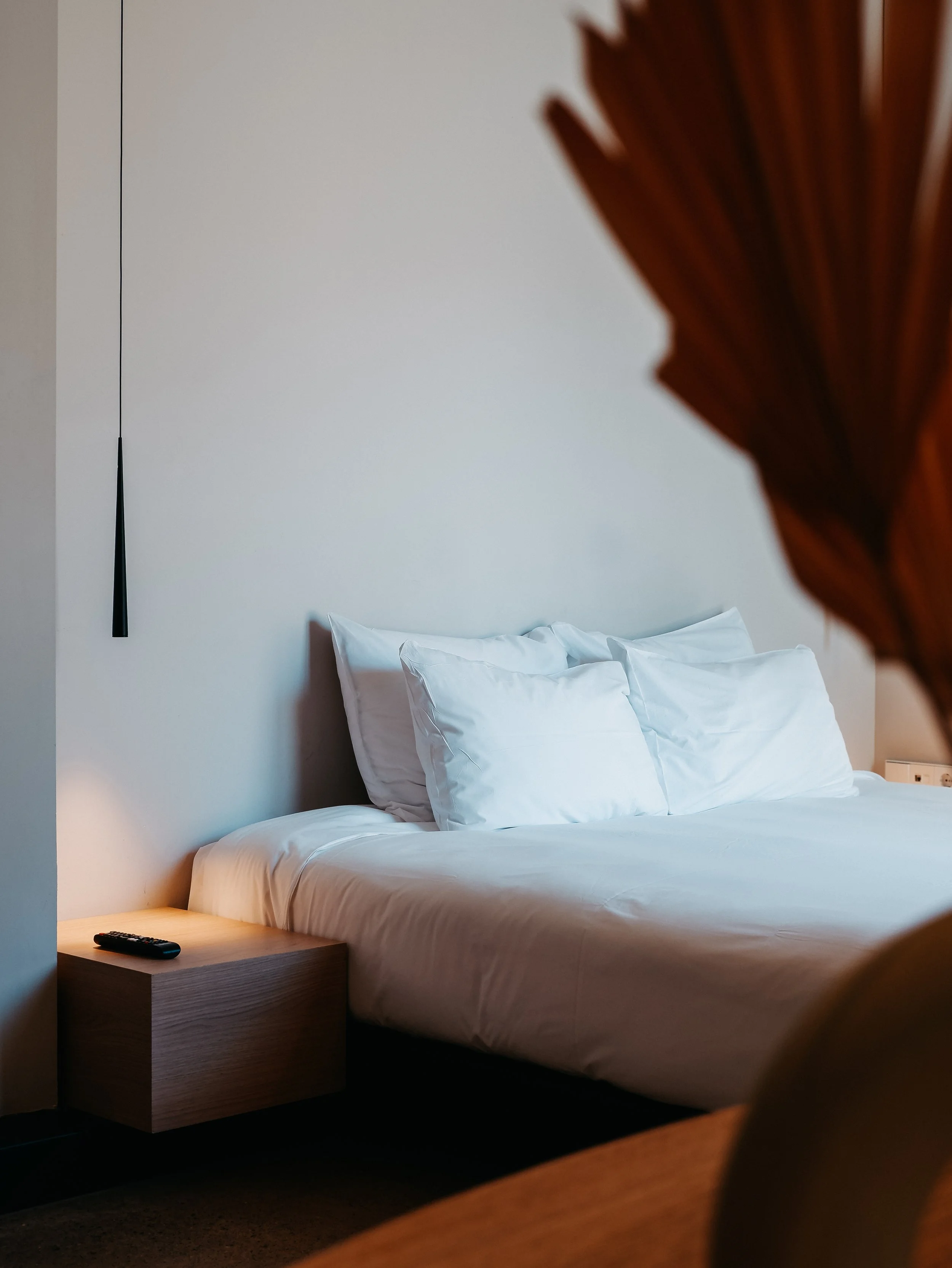Serene boutique bedroom featuring crisp linens, warm wood accents, and calming interiors