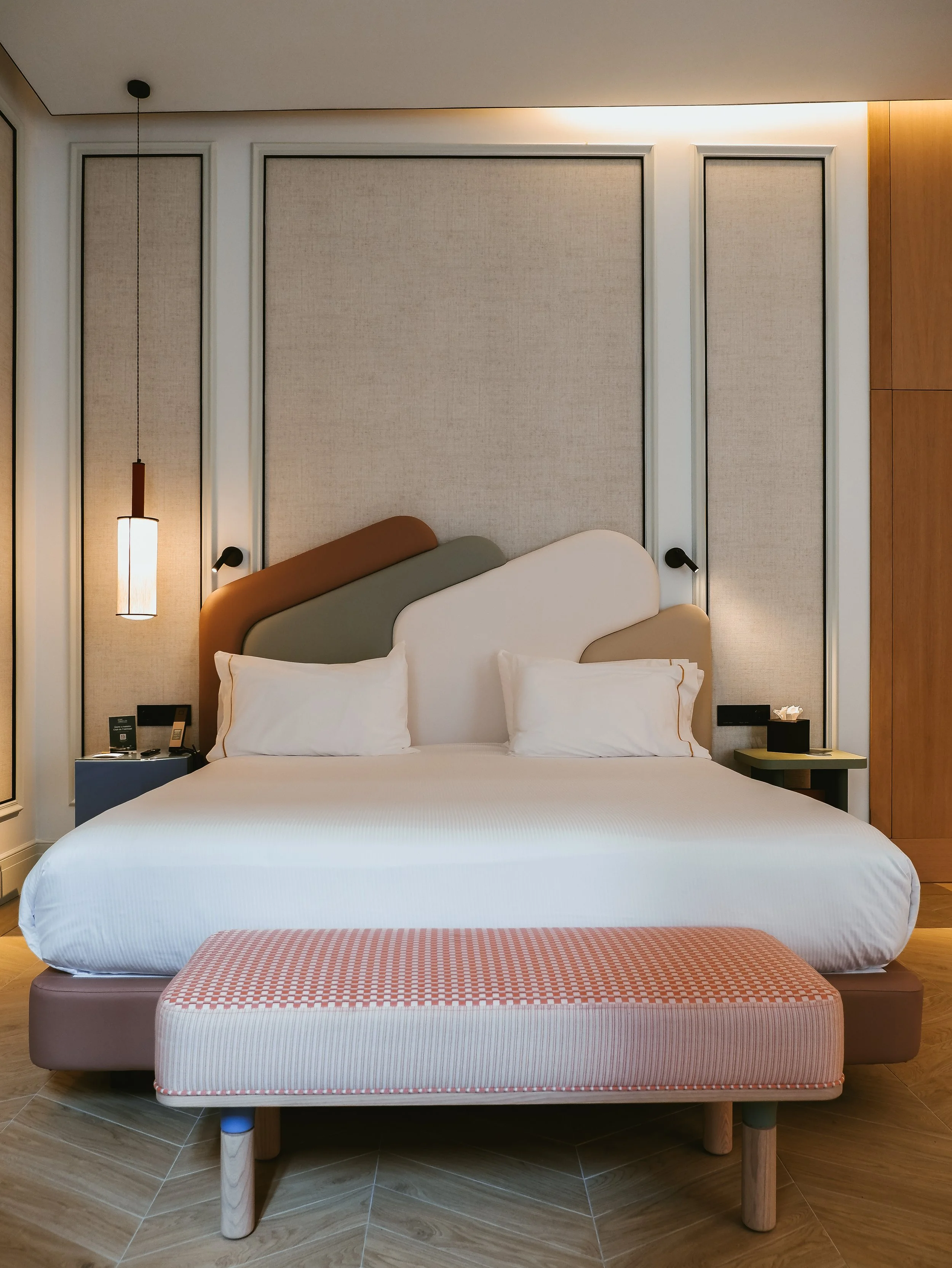 Spacious bedroom featuring a sculptural headboard and refined modern design